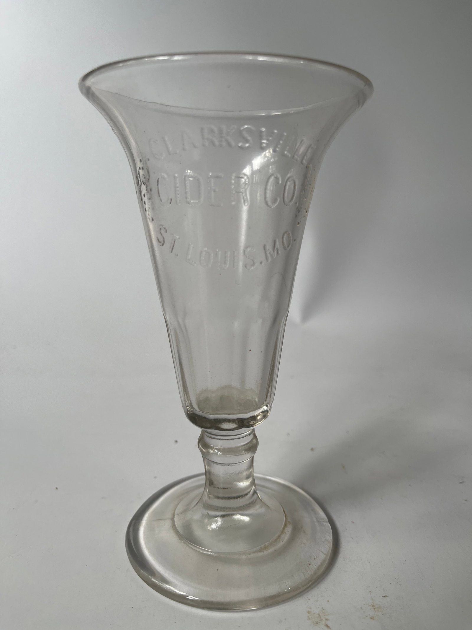 Clarksville Cider Co. St. Louis, Mo stemmed glass.: Here's a Clarksville Cider Co. St. Louis, Mo stemmed glass. The glass is an unusual form. The lip is flared out. The glass has no damage.