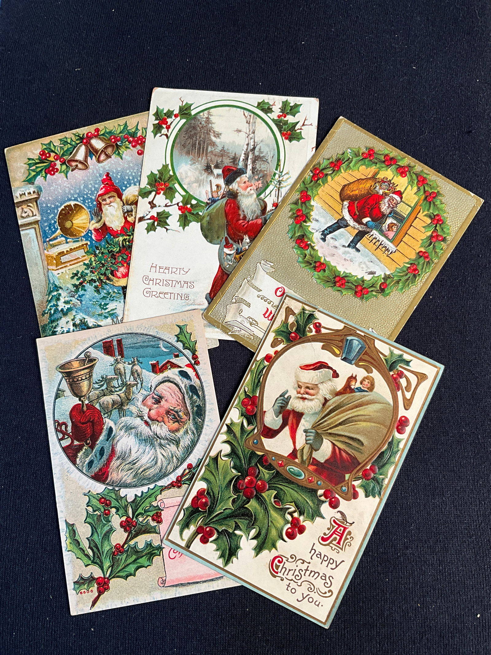 Post Cards, 1908- 1910, Lot of 5 Santa with Holly Postcards: Santa with Holly - postmarked 1908 and 1910. One card depicts a victrola. One card had long creases and a repaired corner.