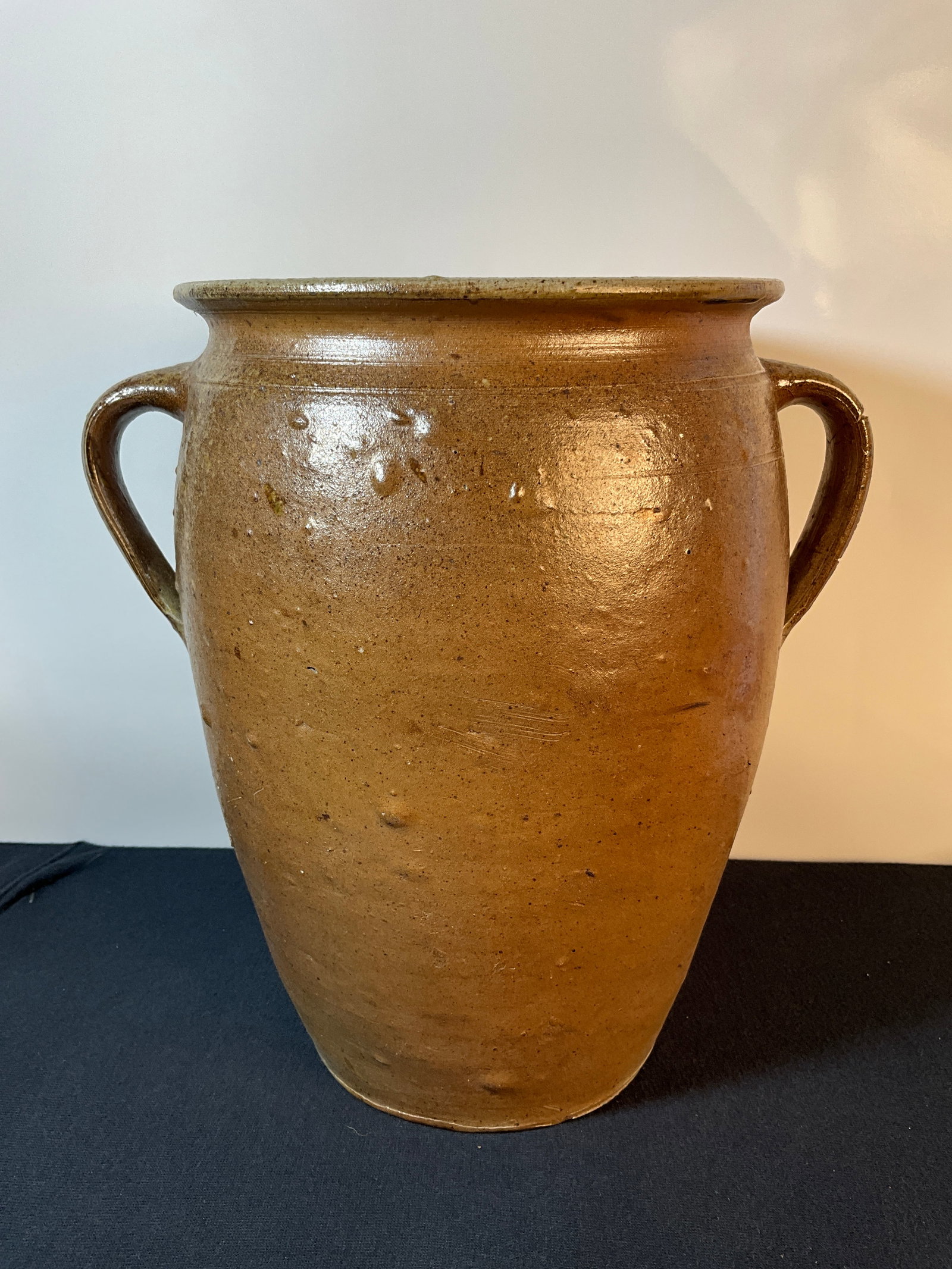 Southern Ovoid Stoneware Crock with Salt Glaze Finish, Green Salt Glaze on the Inside: This is a southern ovoid-style crock with two open handles. The finish is a salt glaze. The inside salt glaze has a green tint. It is a crude piece with a great deal of bubbles. Please see pictures. T