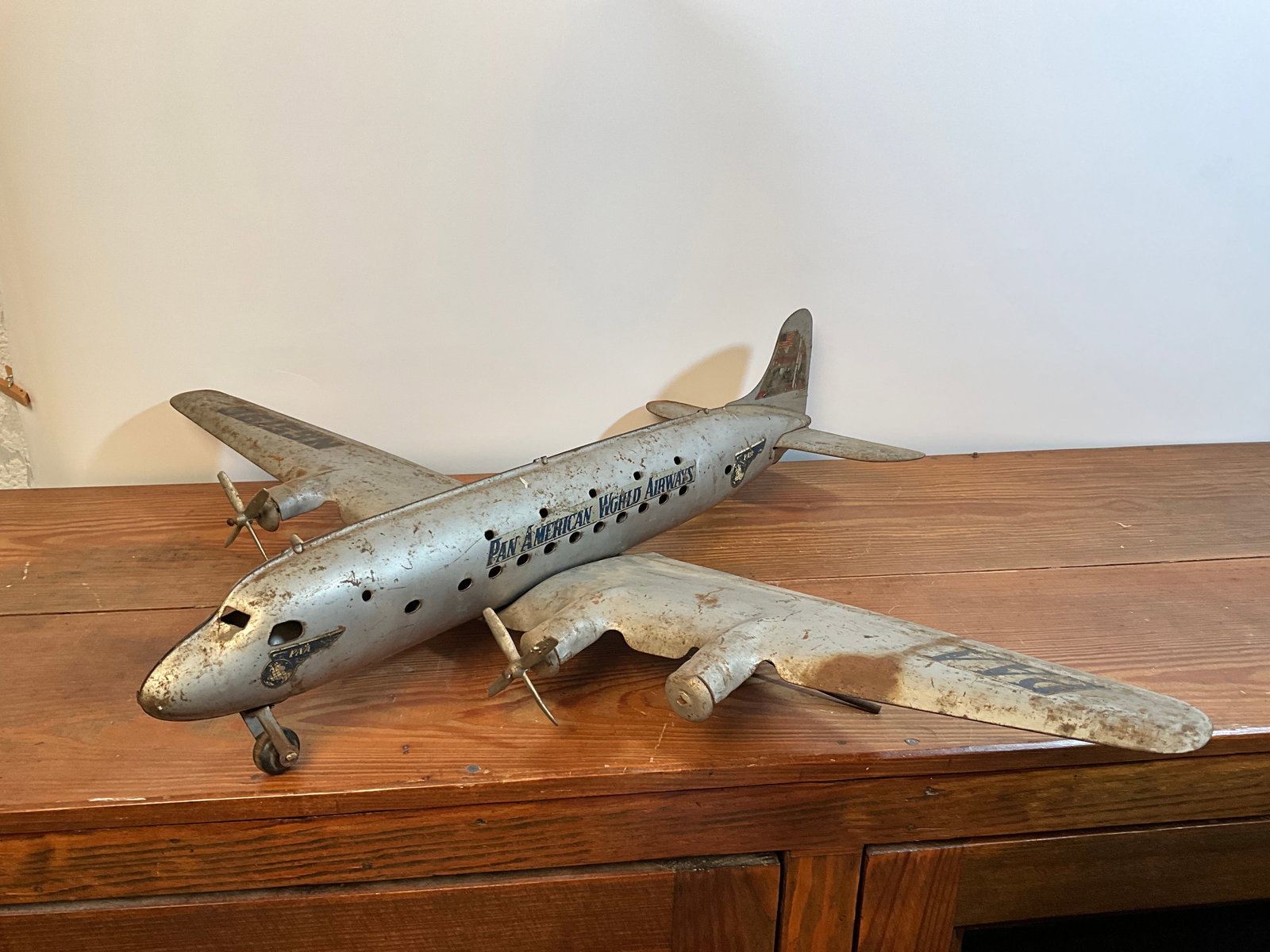 Vintage 1950s PAN AMERICAN WORLD AIRWAYS Airplane Stamped Metal 27.5" Wingspan 22" Long: Vintage 1950s PAN AMERICAN WORLD AIRWAYS Airplane Stamped Metal 27.5" Wingspan 22" Long. This is the largest example that I could find. The wings will separate from the body, for easy transport. There