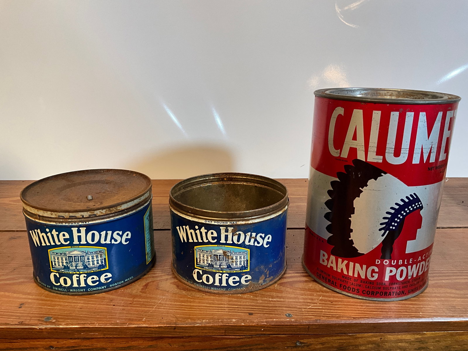 Lot of Three Assorted Tins, Two White House Coffee Tins, One Calumet Baking Powder: Lot of three tins. One Calumet Double-Acting Baking Powder five pound tin with lid. Two White House Coffee tins, one with a lid, and one without a lid. Each are one pound. Please see photographs. You