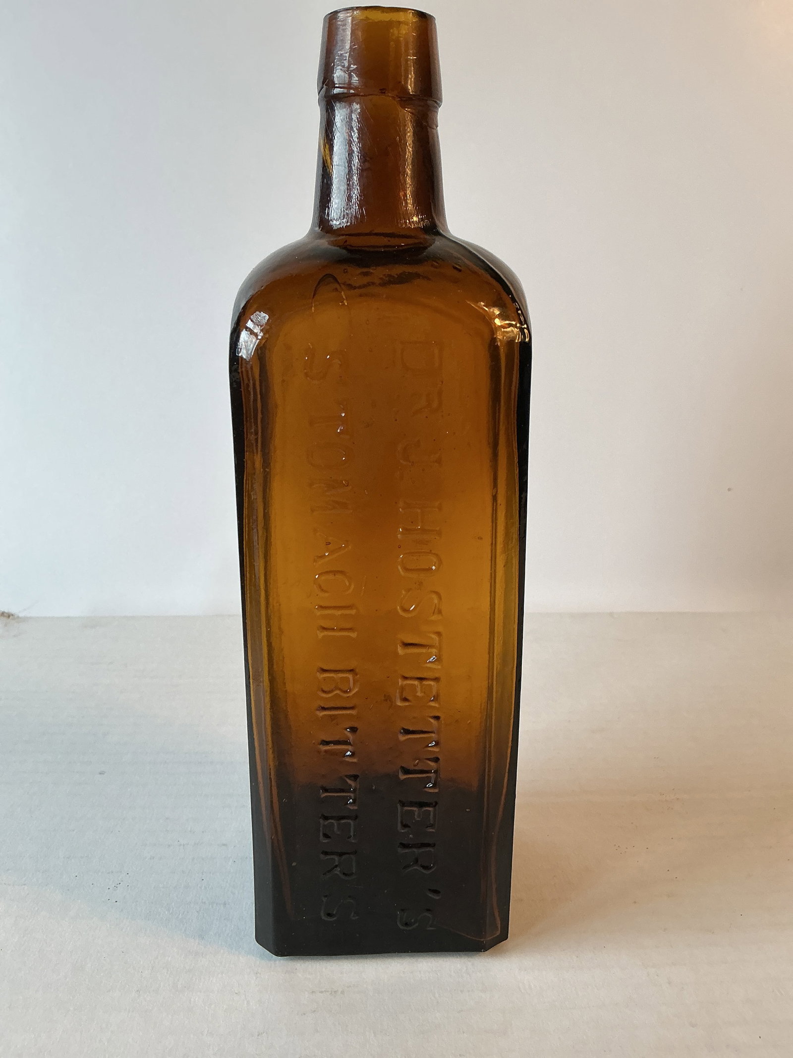 Dr. J. Hostetter's Stomach Bitters, Early Amber: Dr. J. Hostetter's Stomach Bitters in an odd amber color. Maybe a little olive in it. The bottle is very crude with an applied top tons of whittle. No damage or stain. Base is embossed W. Mc C & Co. w