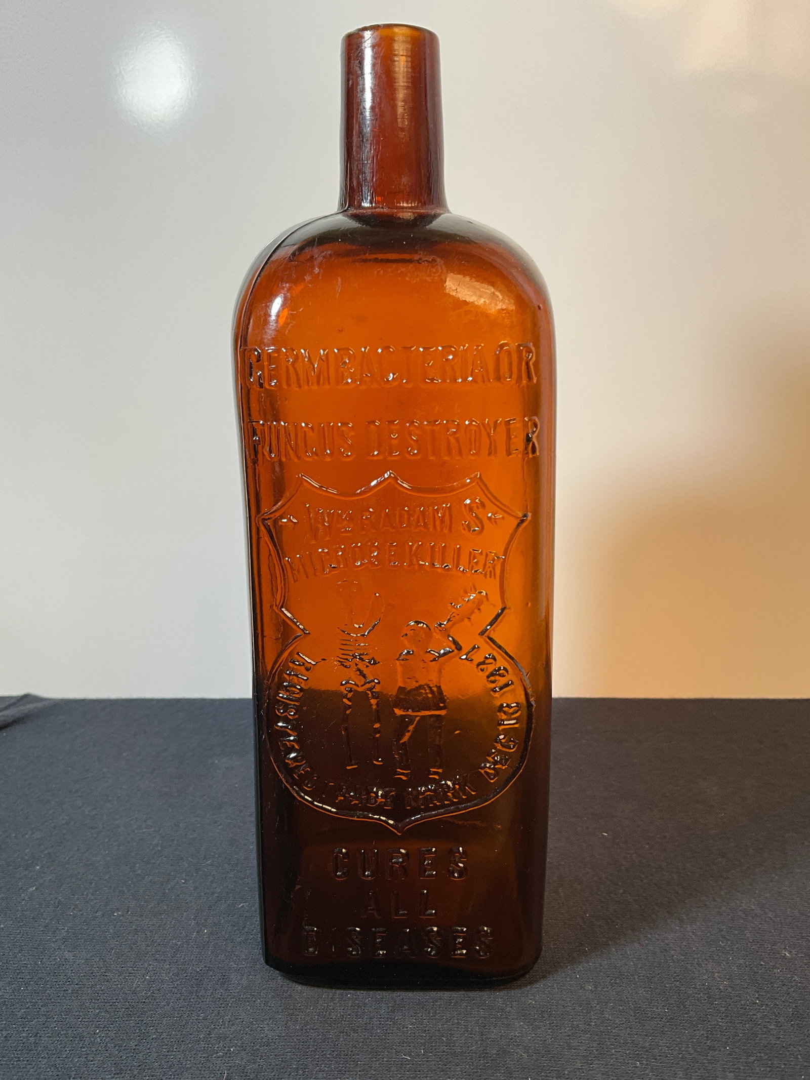 Wm Radams Microbe Killer Cure (embossed with a man beating a skeleton) Amber Bottle: Here is an Wm Radams Microbe Killer Cure (embossed with a man beating a skeleton) Amber Bottle. Slight roughness on the lip, cannot see it but can feel it. Lite amber and would clean up nice. A neat b