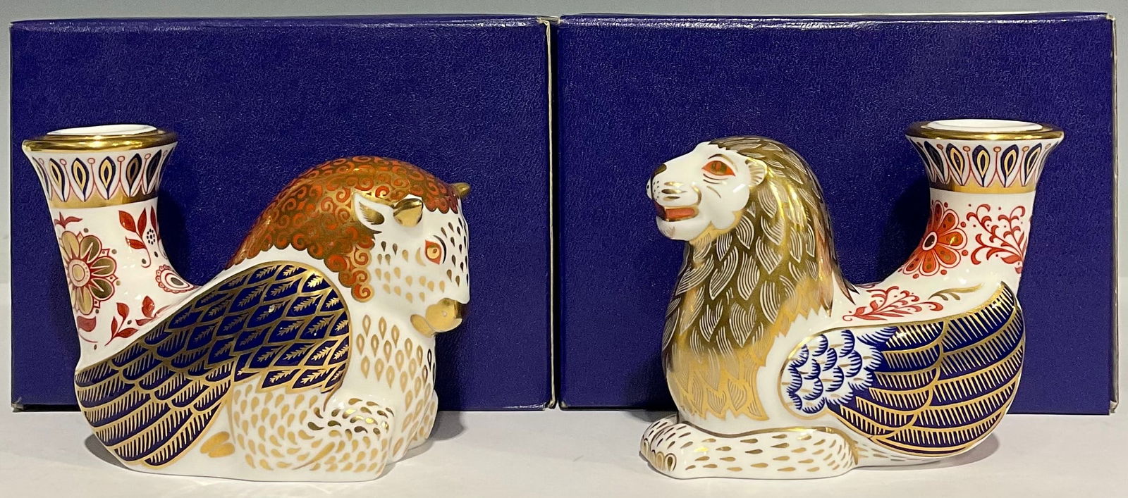 Two boxed Royal Crown Derby 4inch candleholder/paperweights; Lion and a Bull. Gold stopper: Royal Crown Derby candleholder/paperweight, inspired by mythical creatures, Lion, 8.5cm high, gold stopper, boxed; another, Bull, 8.5cm high, gold stopper, boxed (2) In original box. Like new conditio