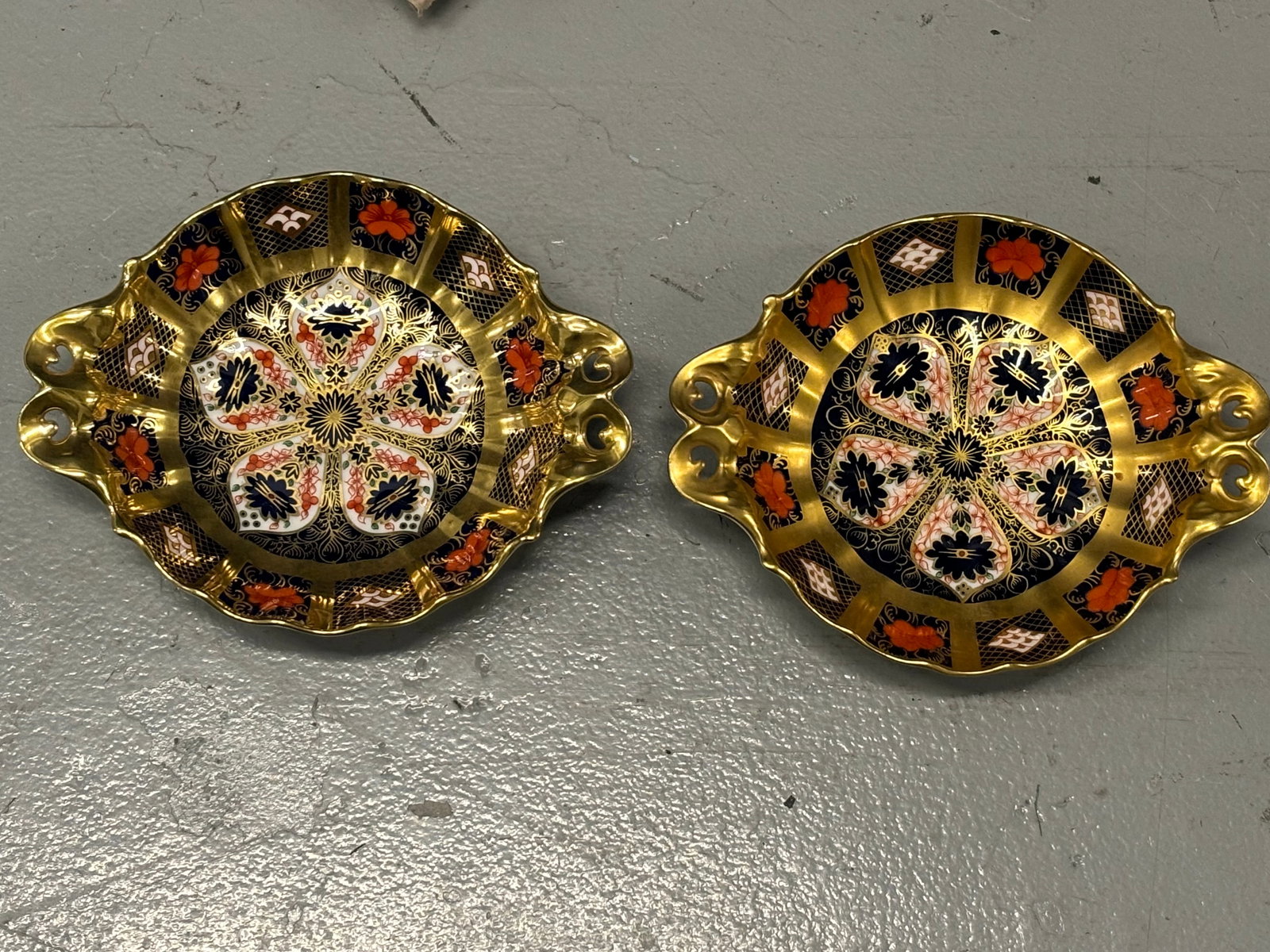 Pair Imari 1128 gold band Royal Crown Derby English fine china 6 inch shaped footed dishes: Pair Imari 1128 gold band Royal Crown Derby English fine china 6 inch shaped footed dishes.Very bright and clear colors. Double pierced through edge handles.No box.Very good condition with no chips, c
