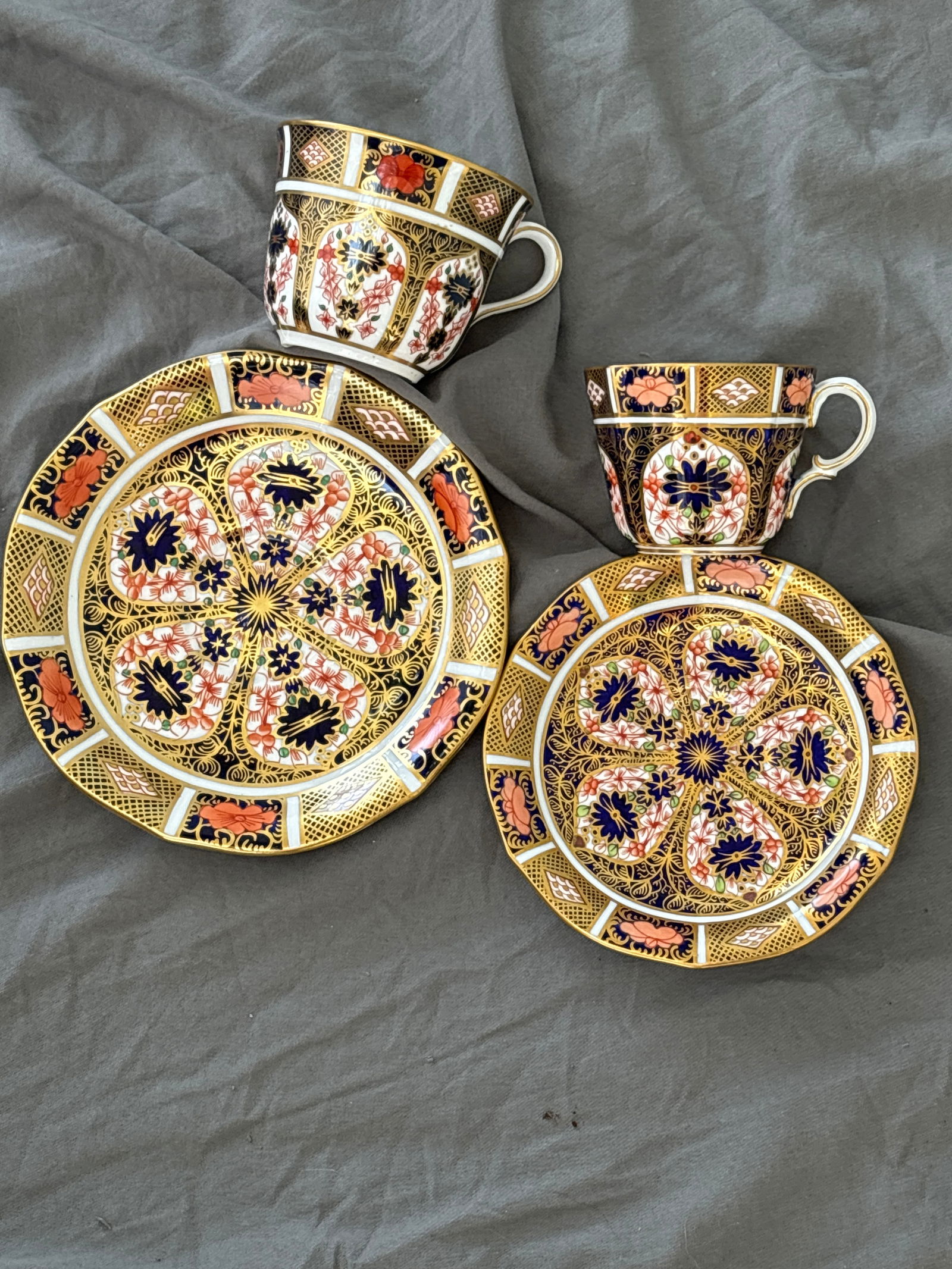 Two similar Imari 1128 pattern Royal Crown Derby cups & saucers: Two Imari 1128 pattern Royal Crown Derby cups with saucers. Larger cup 2&7/8 high by 3&1/2 across with Saucer 6&5/8. Smaller cup has shaped 2&1/2 high by 3 inches and 5&1/2 saucer. Very good condition