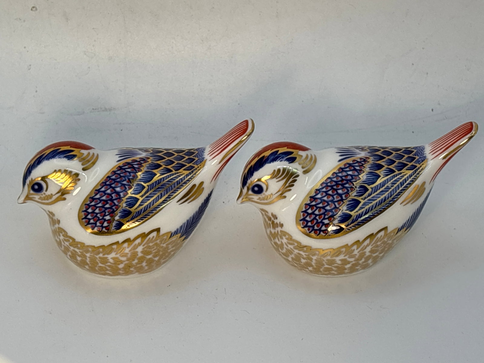Two Goldcrest bird form Royal Crown Derby 3&1/2 inch paperweights: Two Goldcrest bird form Royal Crown Derby 3&1/2 inch paperweights.No boxes.One silver stopper & one with no stopper.Both in very good condition