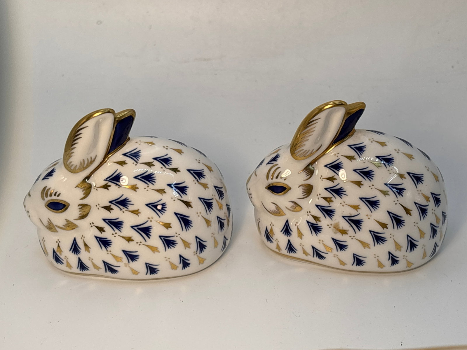 Two blue design Imari rabbit form Royal Crown Derby 3&1/2 inch paperweights: Two rabbit form Royal Crown Derby 3&1/2 inch paperweights.No boxes.One gold stopper & one with white stopper.Both in very good condition