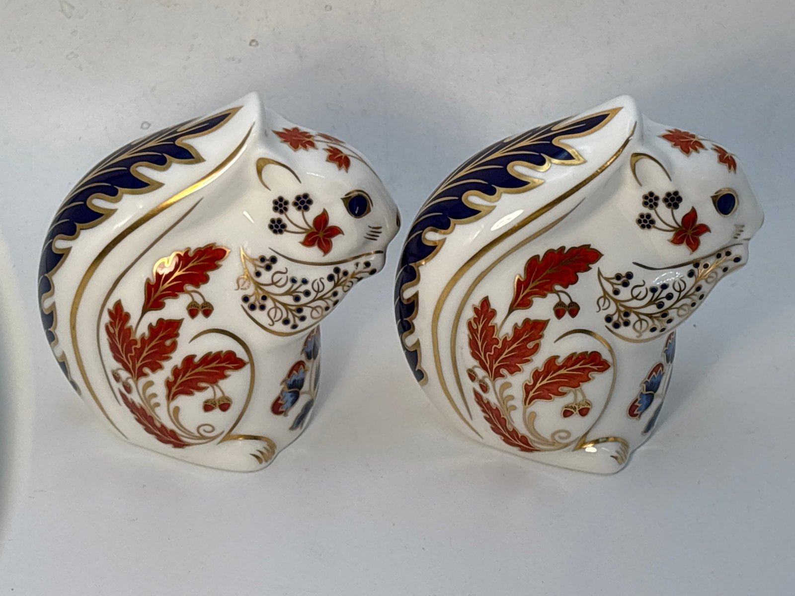Two Autumn Squirrel form Royal Crown Derby 4inch paperweights: Two Autumn Squirrel form Royal Crown Derby 4 inch paperweights.No boxes.One gold stopper & one with silver stopper.Both in very good condition