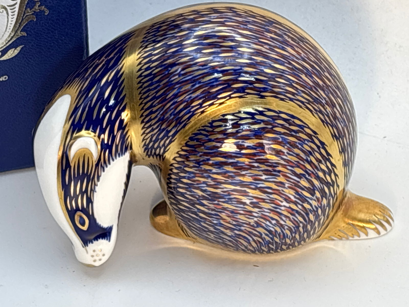 Blue glazed Imari ‘Badger’Royal Crown Derby English bone china 4 inch paperweight: Imari “Badger”Royal Crown Derby English bone china 4inch paperweight. Gold stopper. With Box.Very good condition; no chips, cracks, etc