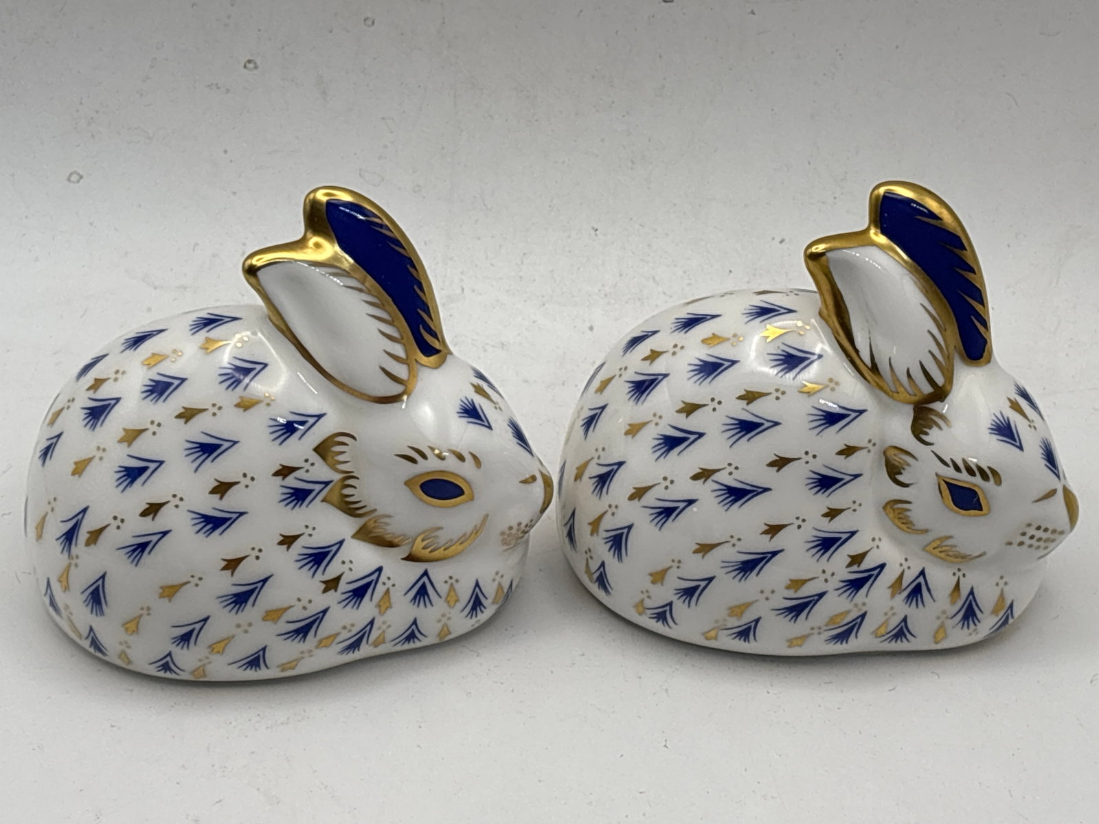 Two blue decorated bunny rabbits Royal Crown Derby 3 inch paperweights: Two rabbits; “Bunny Rabbit” Royal Crown Derby 3 inch paperweights. No box.Both gold stoppers.No chips, cracks, etc.