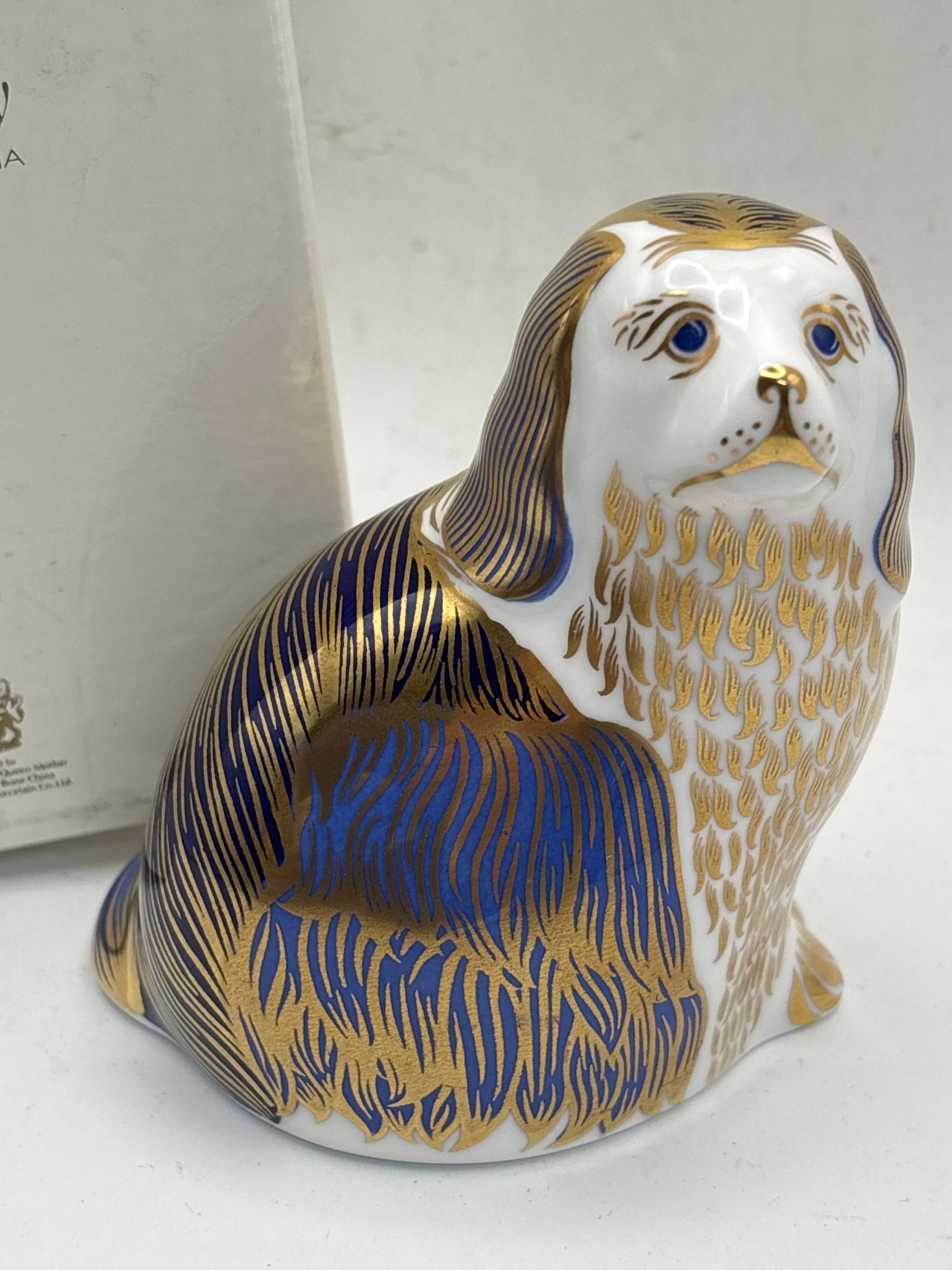 Regal ‘King Charles Spaniel’ dog Royal Crown Derby china 4 inch paperweight: Regal ‘King Charles Spaniel’ dog Royal Crown Derby china 4inch paperweight. Silver stopper. With box.No chips, cracks, etc.