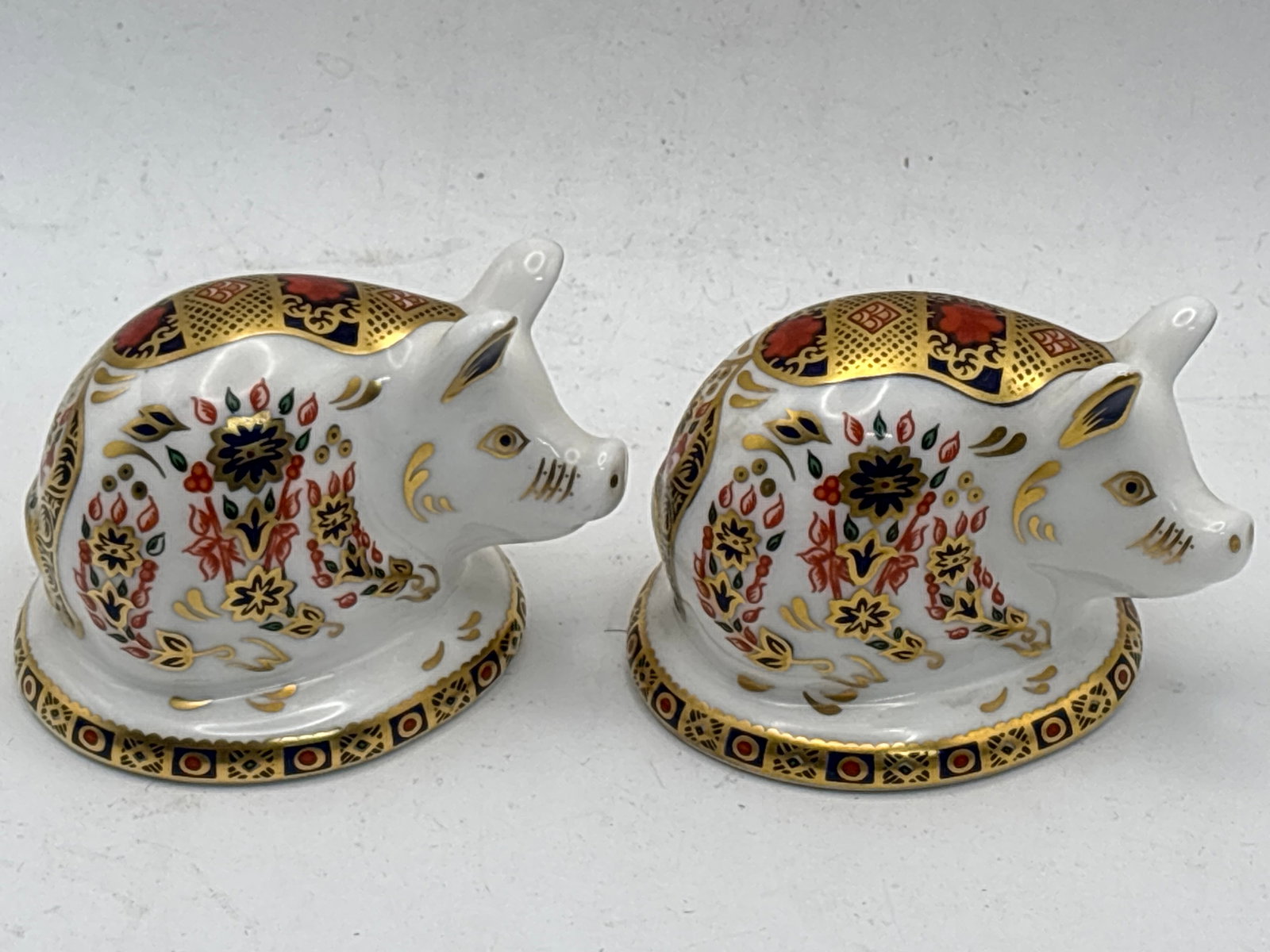 Two Imari Piglet form Royal Crown Derby 2&1/2 inch paperweights: Two piglet Royal Crown Derby 2&1/2 inch paperweights. gold stopper. No box. Excellent condition