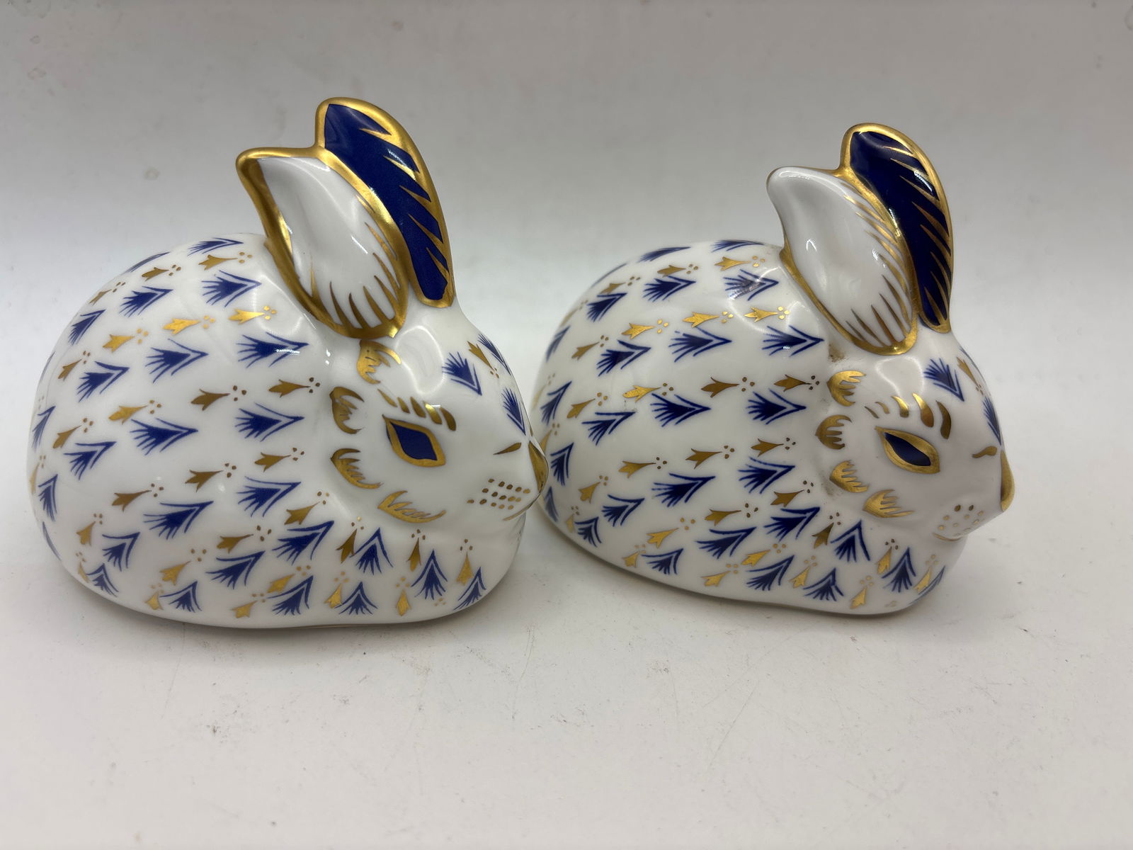 Two Rabbit form Royal Crown Derby 3 inch paperweights: Two rabbits Royal Crown Derby 3 inch paperweights. No box. One silver and one Gold stopperVery good condition.