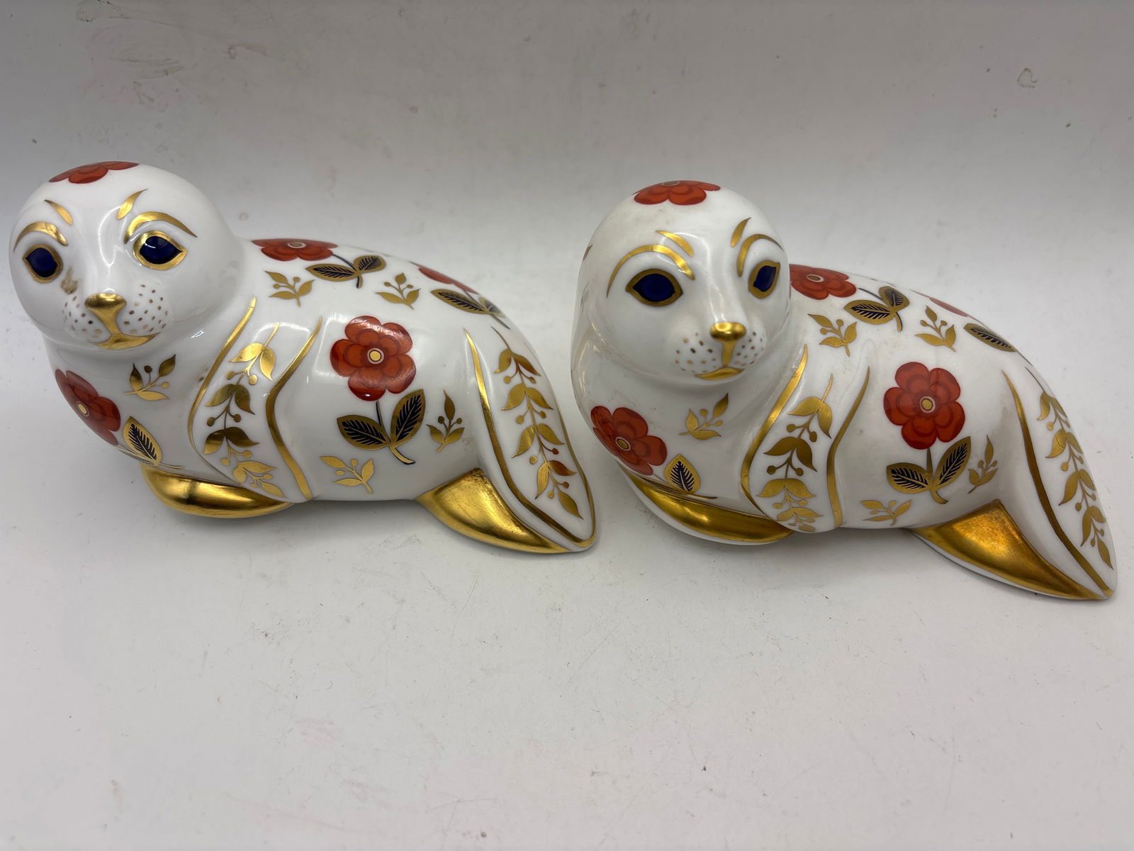 Two Harbour Seal pattern Royal Crown Derby 5 inch paperweights: Two Harbour Seal pattern Royal Crown Derby 5 inch paperweights. No box. One good stopper & one without stopper. Very good condition