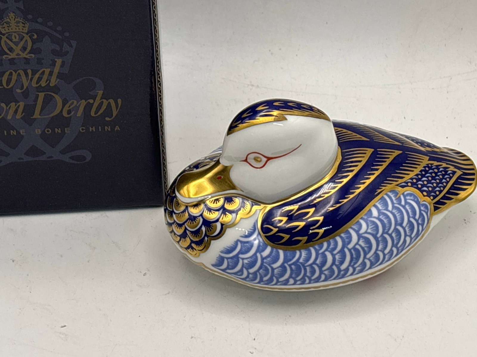 Peking duck form Royal Crown Derby England 4&1/2 inch paperweight: Duck form Royal Crown Derby England 4&1/2 paperweight . With box. Gold Stopper.Very good condition