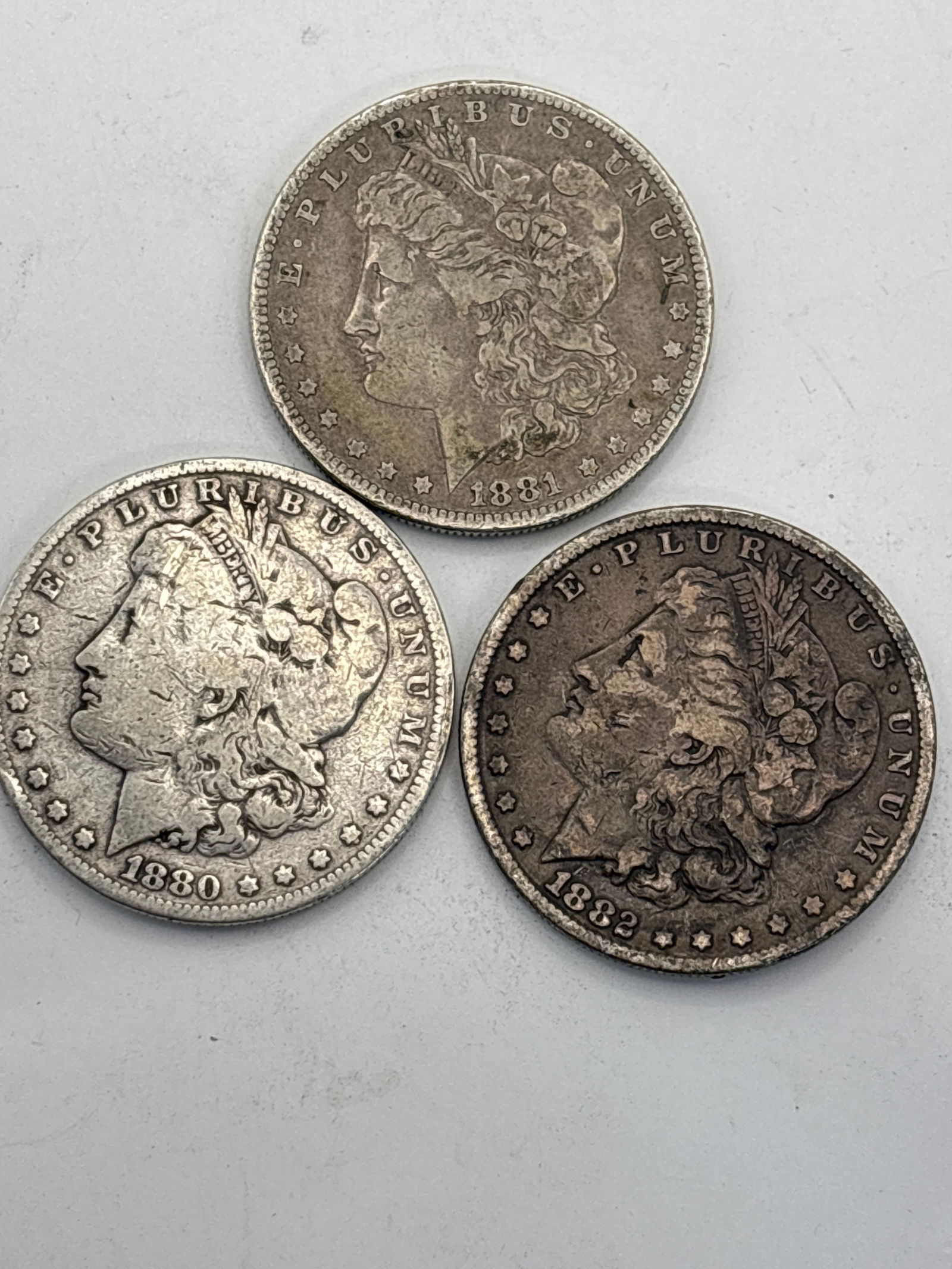 Three early 1880’s American Morgan silver dollars; worn (1 of 5)