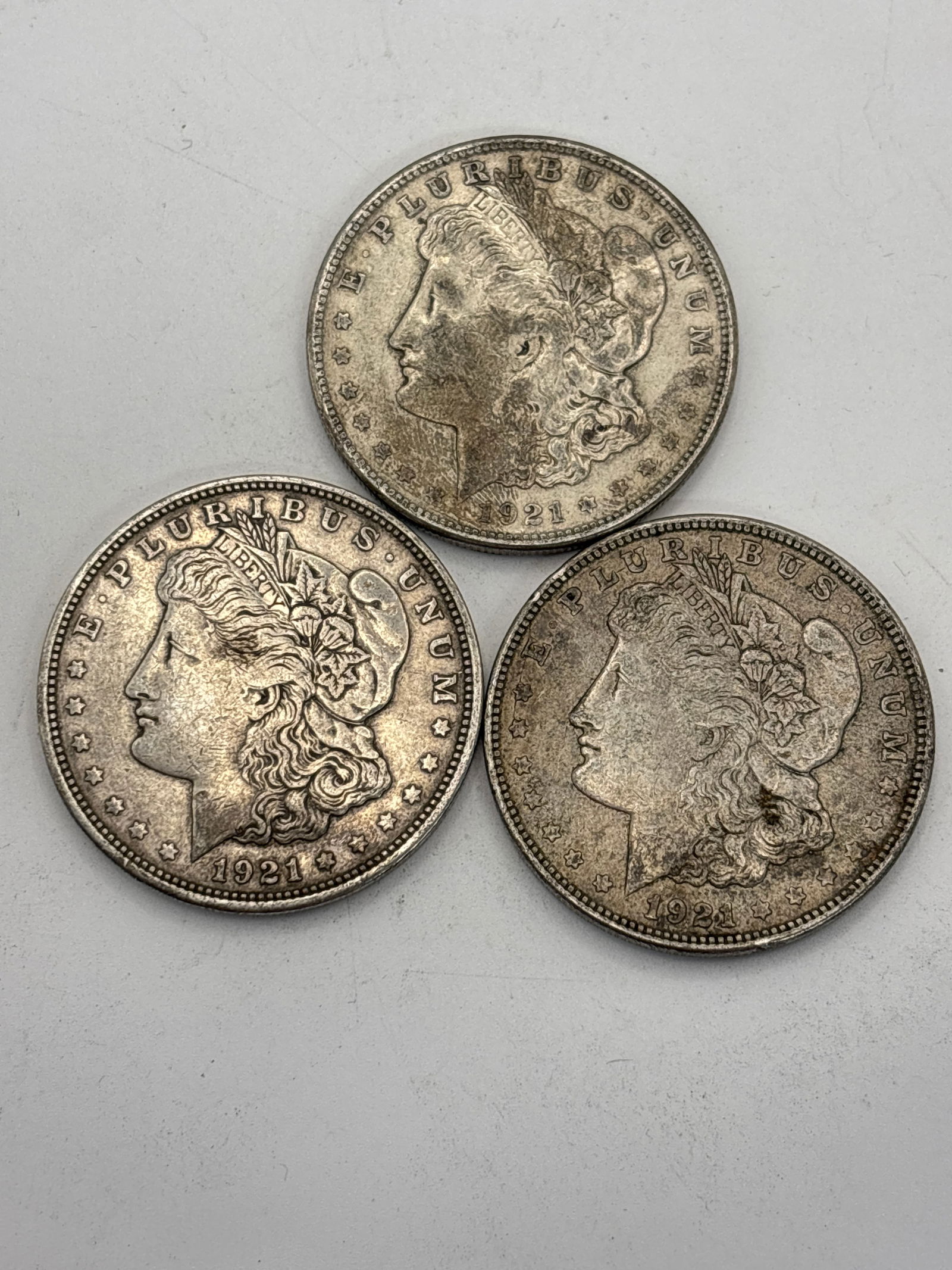Three dated 1921American Morgan silver dollars; worn (1 of 5)