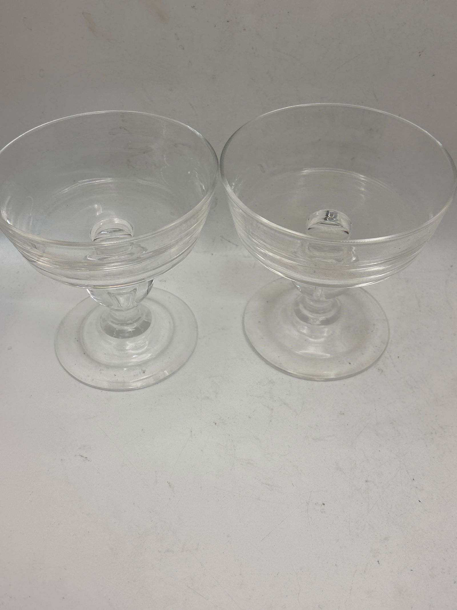 Two signed Steuben crystal 4 inch champagne or tall sherbet glasses: Two signed Steuben crystal 4 inch champagne or tall sherbet glass. This specific pattern (often identified as #7877 or #7926) was designed by George Thompson and features a baluster stem with a contro