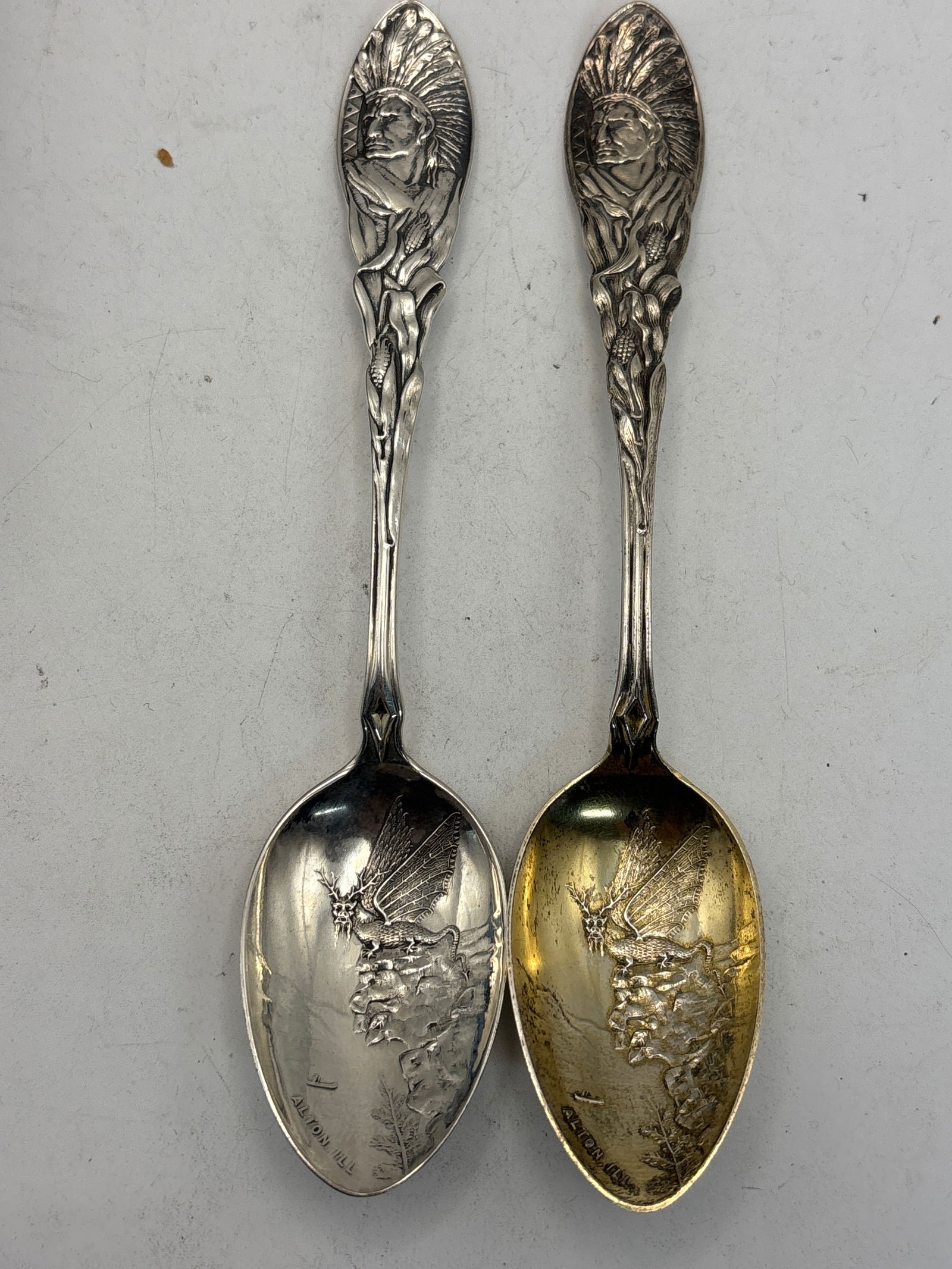 Pair dragon design & Native handle Sterling silver 5&7/8 inch souvenir spoons; 50grams: Pair dragon design & Native handle Sterling silver 5&7/8 inch souvenir spoons; 50grams. One has a good wash bowl. Alton, I’ll and one with patent date of 1891. Circulated used condition