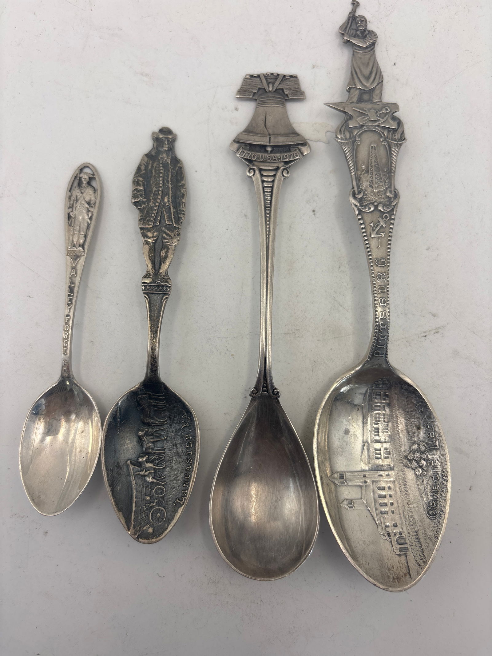 Rare Four Pennsylvania sterling silver souvenir spoons; 68 grams: Four Pennsylvania sterling silver souvenir spoons; 68 grams. A rare 5&3/4 inch 1904 Carnegie Library Pittsburgh oil rig , steel worker handle, a Liberty bell, a William Penn handle Lancaster with Cone
