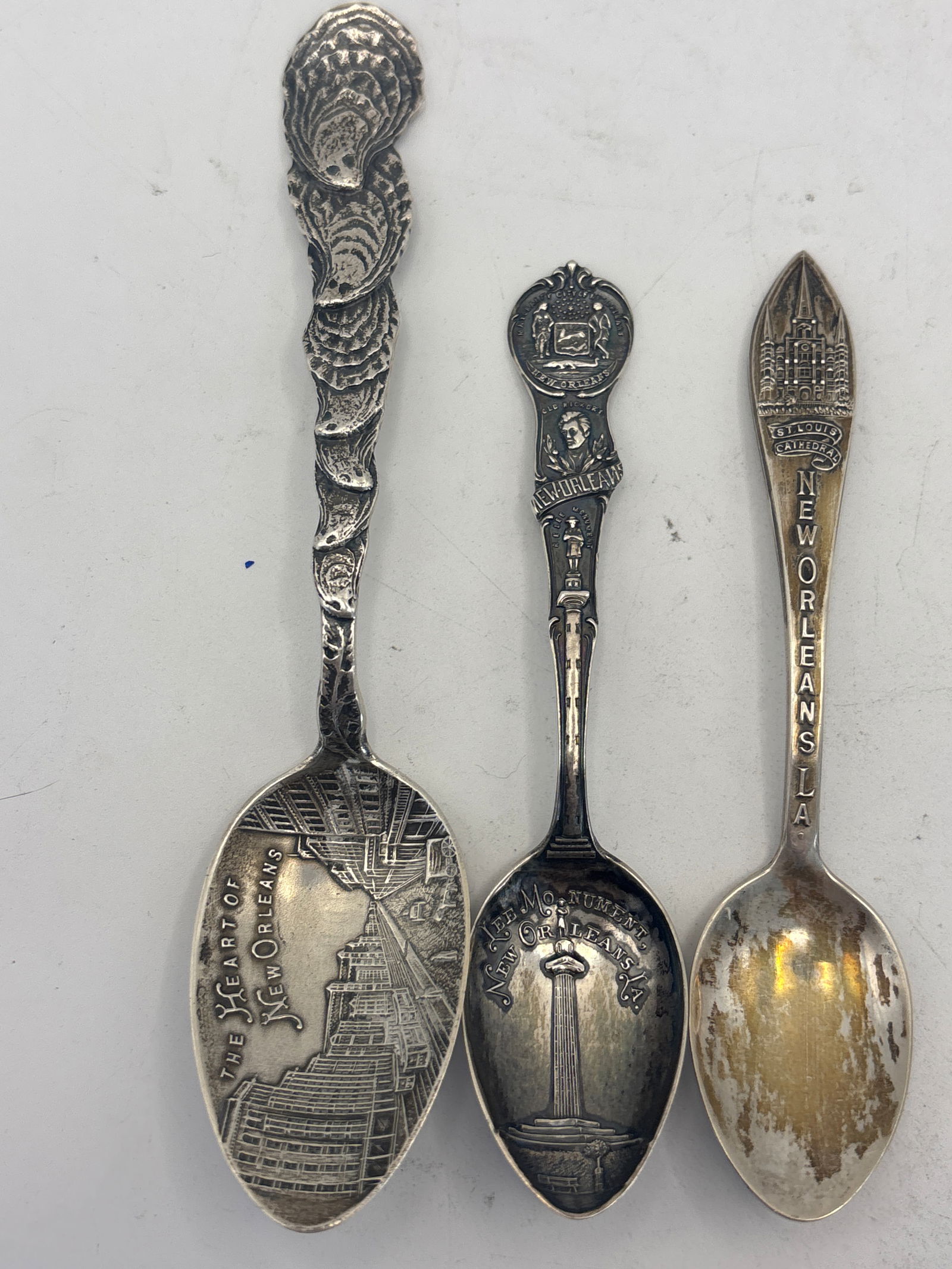 Three New Orleans sterling silver souvenir spoons; 42 grams: Three New Orleans sterling silver souvenir spoons; 42 grams. A rare clam shell handle Heart of New Orleans 5&1:4, a 4&1/4 Lee Monument and St. Louis. Used