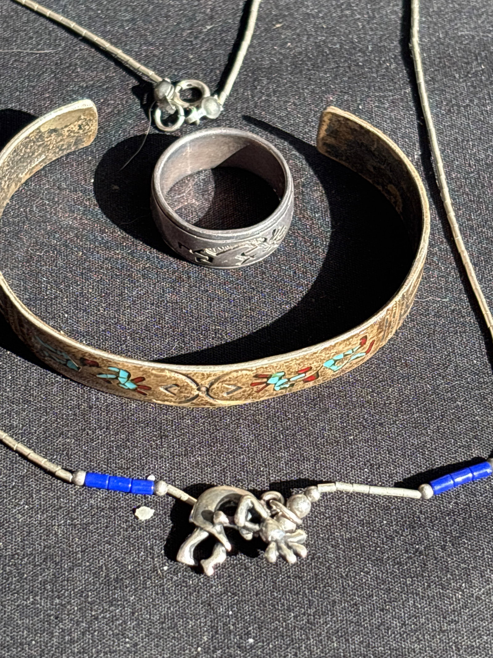 Three Kokopelli Hopi handcrafted sterling silver ring, necklace & bracelet; 26 grams: Three Kokopelli Hopi handcrafted sterling silver ring, necklace & bracelet; 26 grams. The bracelet is inlaid & artist initialed & is 5&3/4 inches interior circumference. Ring is size 6&1/2, necklace i