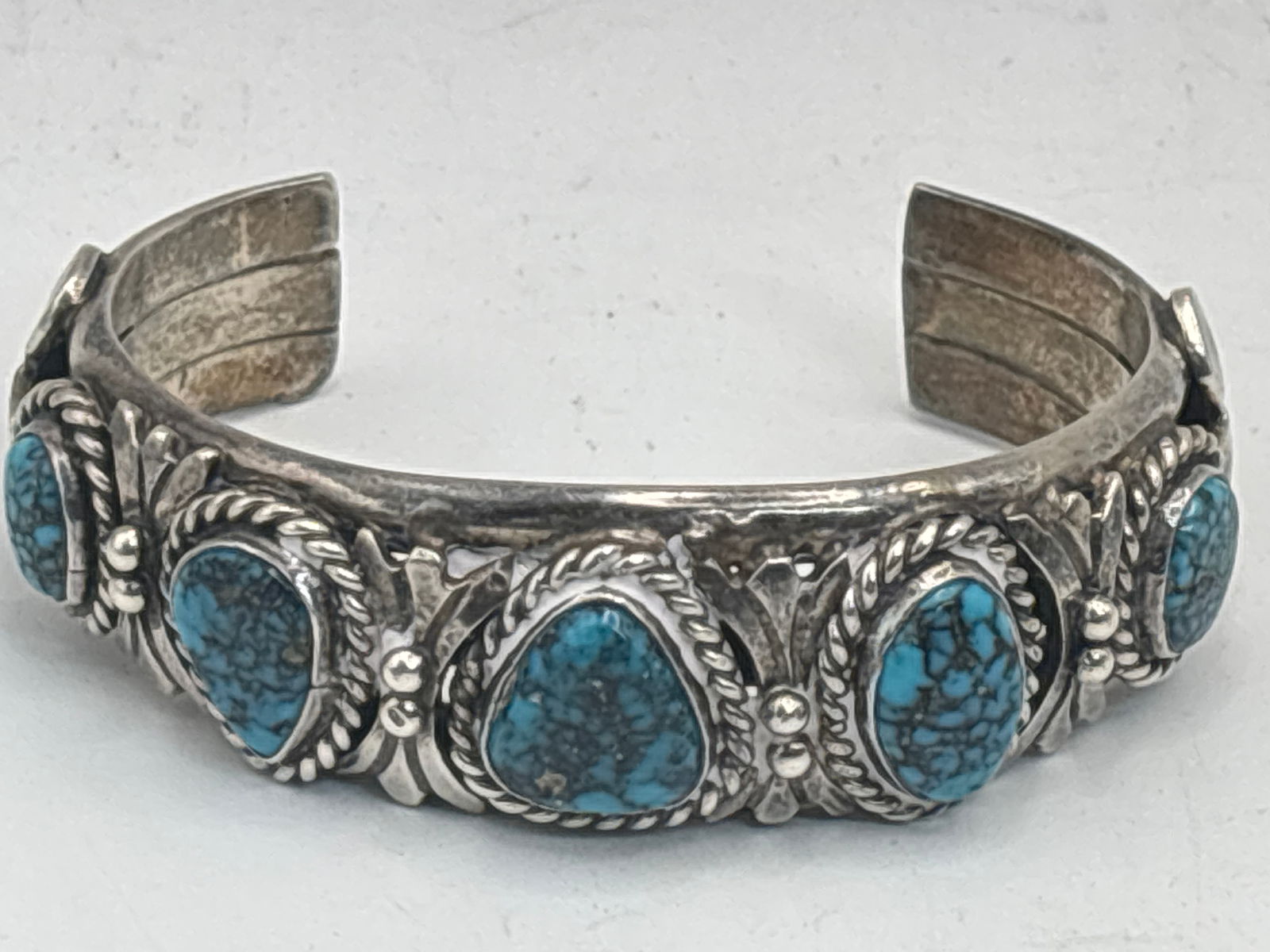 Heavy Native American turquoise stone & sterling silver cuff bracelet; 71 grams: Heavy Native American turquoise stone & sterling silver cuff bracelet; 71 grams. Interior circumference is 5&1/2 inches. Underwire five turquoise stones.