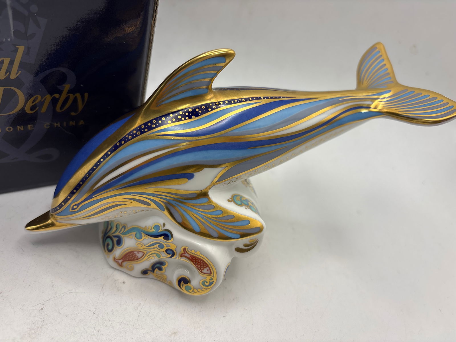 Gorgeous ‘Strioed Dolphin’ Royal Crown Derby 7 inch paperweight: With box. Silver stopper.Royal Crown Derby "Striped Dolphin" Imari paperweight. It is made of English bone china and decorated in the traditional Imari colors with 22-carat gold accents. The piece was