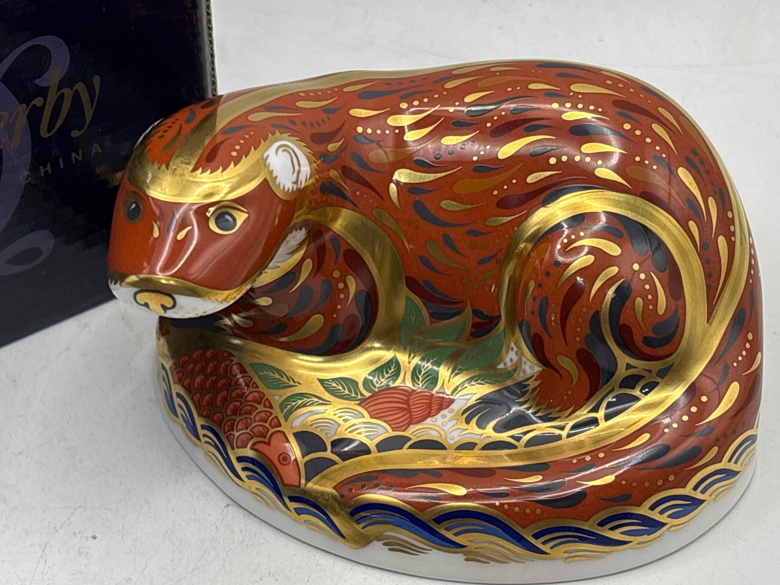 Wonderful 2001 Imari Otter Royal Crown Derby 4.5 inch paperweight: Royal Crown Derby Otter paperweight. It is made from bone china. The design is hand-decorated in the traditional Imari style, featuring rich red, blue, and gold colors. It was introduced in 2001 and m