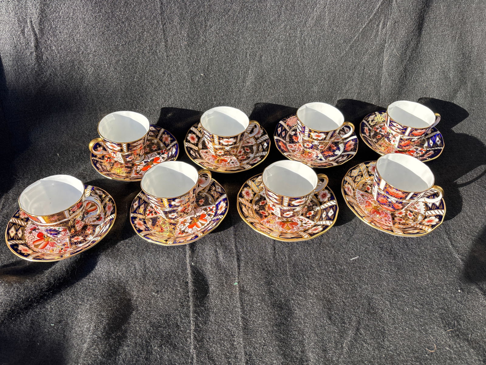 Serving eight Inari #2451 pattern Royal Crown Derby tea cups with saucers: Gold stopper. With box.Royal Crown Derby "Sleeping Ginger Kitten” paperweight, known for its distinctive orange/red and white Imari pattern. Stands approximately 5 inches tall.Features a vibrant