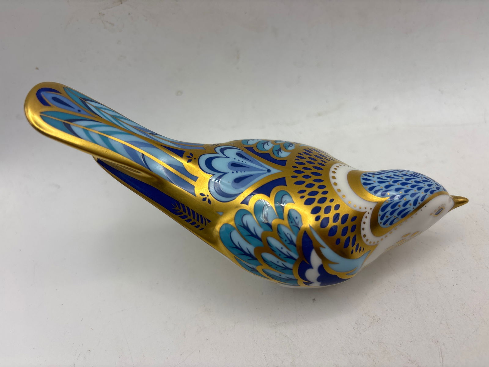 2094 ‘Mountain Bluebird’ Royal Crown Derby 5&1/2 inch paperweight: No box. Gold stopper. Royal Crown Derby Mountain Bluebird paperweight. It is made of bone china and hand-painted with 22ct gold accents. The piece was modeled by Donald Brindley and designed by Jane J