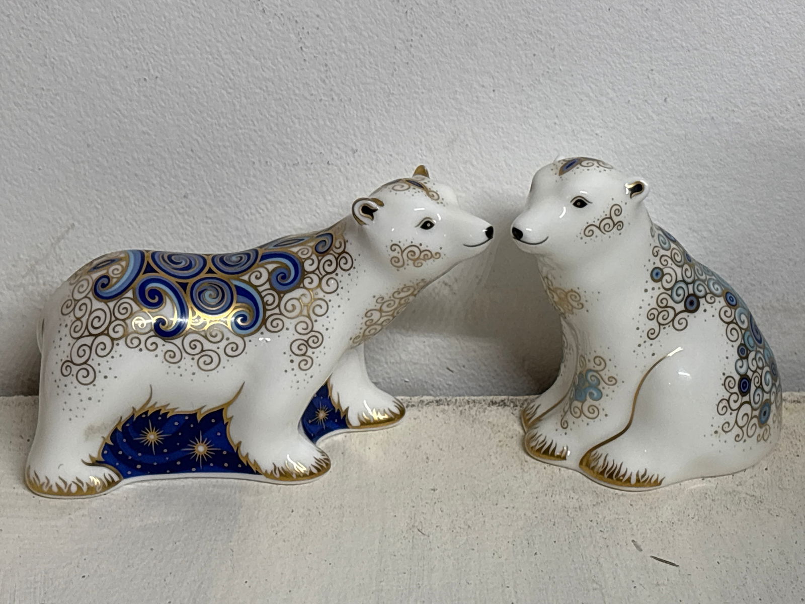Two uncommon Polar Bear l Royal Crown Derby 3&1/2 inch paperweight: second quality.No box. Silver stopper.Two Royal Crown Derby Standing Polar Bear Cub paperweight. It is crafted from fine bone china. The decoration is hand-applied with intricate blue and gold swirls