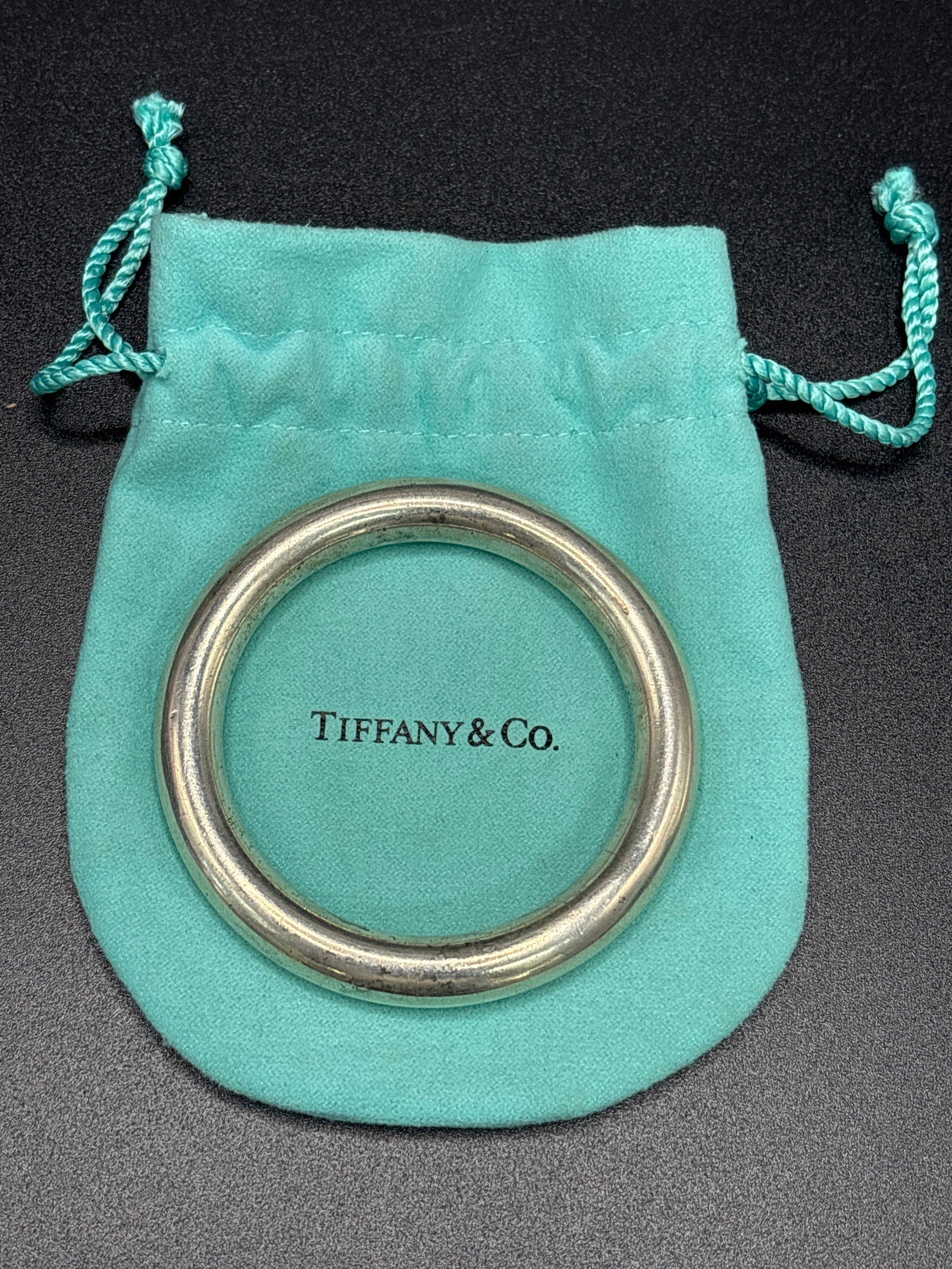 vintage Tiffany sterling silver 2&1/2 inch baby rattle/bracelet w/pouch; 29.5 grams: vintage Tiffany sterling silver 2&1/2 inch across circular baby rattle/bracelet w/pouch; 29.5 grams.