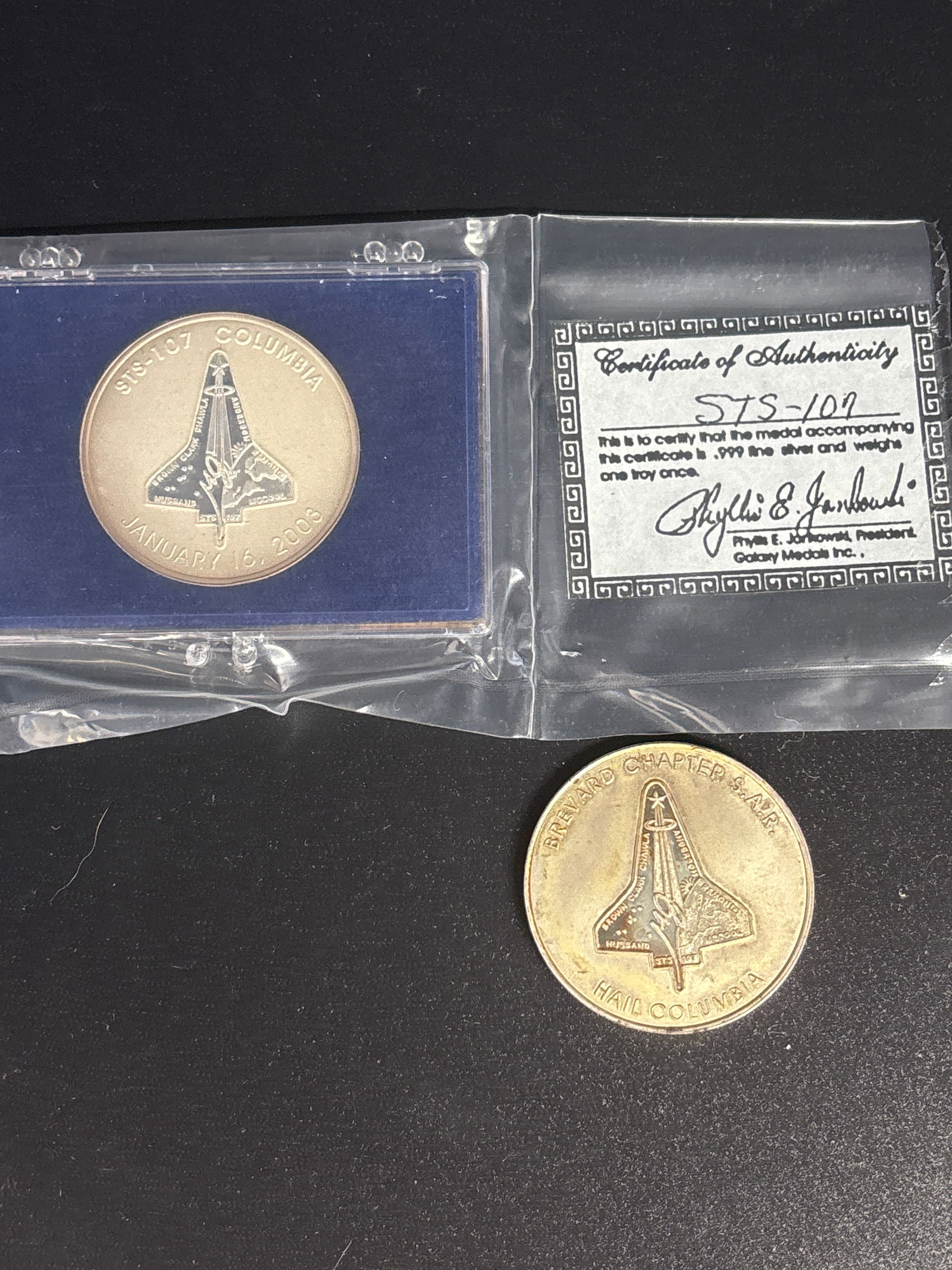 Two 1 T.O. 999 fine silver limited-edition sterling silver medallions of the STS-107 mission medals: Two limited-edition sterling silver medallion of the STS-107 mission medals.Material Variation: Sterling Silver Versions: Separate, limited-edition sterling silver medallions were also produced to com