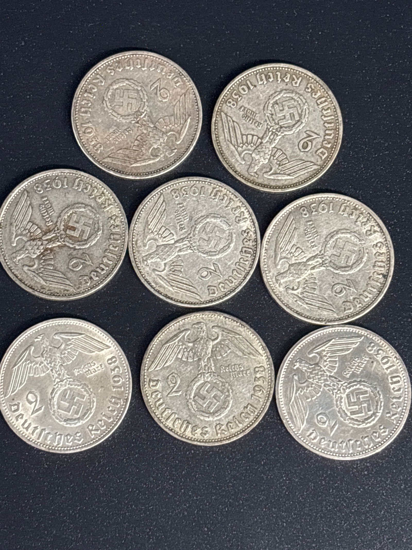 Eight German 2 Reichsmark coin from 1938 Third Reich period: Eight German 2 Reichsmark coin from 1938, issued during the Third Reich period. Material: The coin is composed of silver, typically 62.5%. Design: The obverse features the German national eagle