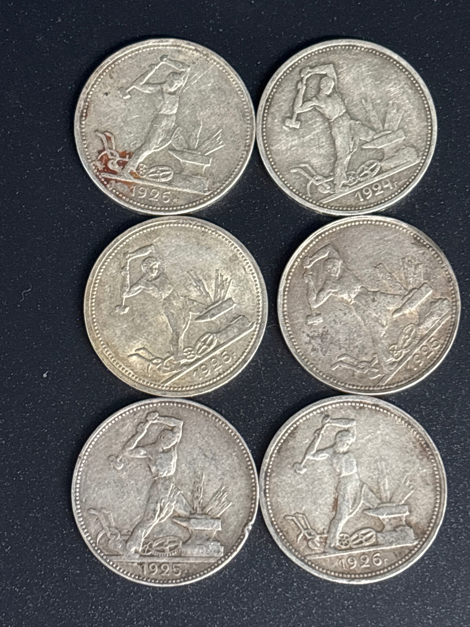Six 1920’s Soviet Union 50 kopeks coins; 40 grams total 90% silver: Six 1920’s Soviet Union 50 kopeks coin, also known as a "poltinnik". It features a blacksmith holding a hammer over an anvil on the reverse side. Material: 90% silver.Weight: Approximately 10