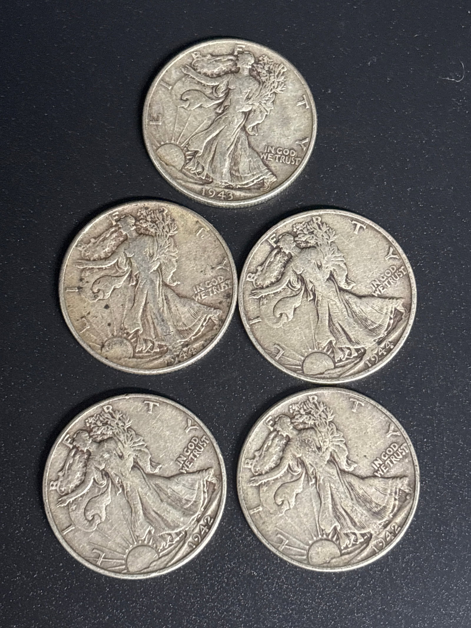 Five WWII era 1940’s Walking Liberty silver Half Dollars: Five WWII era 1940’s Walking Liberty Half Dollars, vintage American coin collectible. Composition: 90% Silver, 10% Copper.Designer: Adolph A. Weinman.Weight: Approximately 12.5 grams.Two 1942, two 1