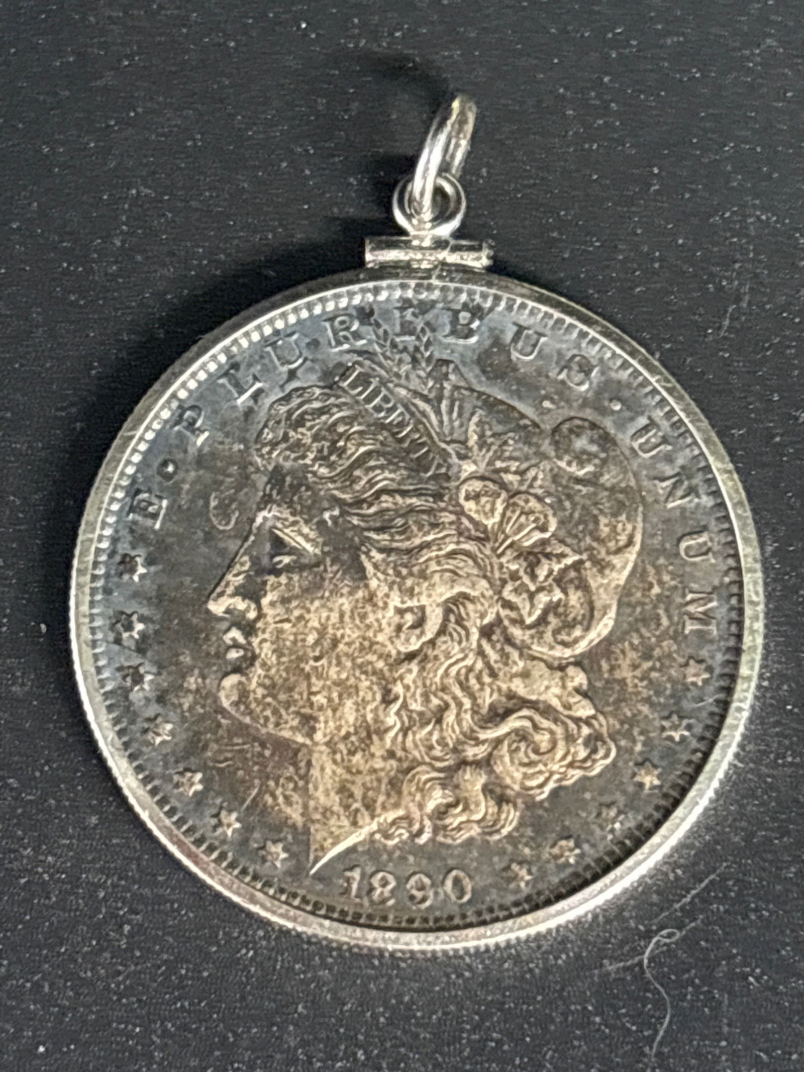 early 1890 United States Morgan silver one dollar coins; mounted as pendant: This has been inserted mounted as pendant. 1890 Morgan Silver Dollar, which was the final year of production for this classic series, known as the "King of America's Coins". Composition: Contains 0.77