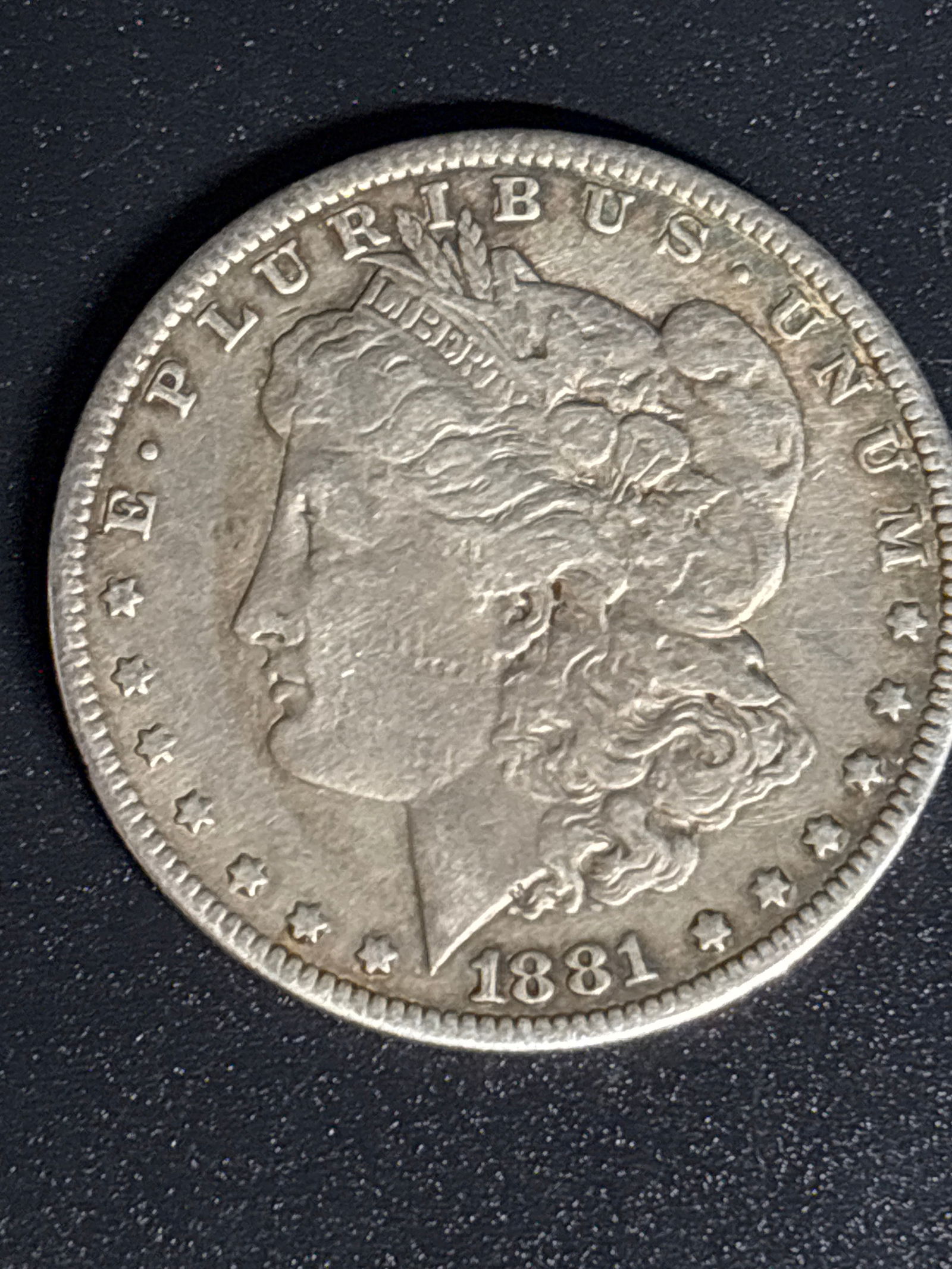 Early 1881 Morgan United States Silver Dollar: 1881 Morgan Silver Dollar.Composition: The coin contains 0.7734 troy ounces of pure silver, with a total weight of 412.5 grains and a fineness of 90% silver. Design: It features a right-profile bust o