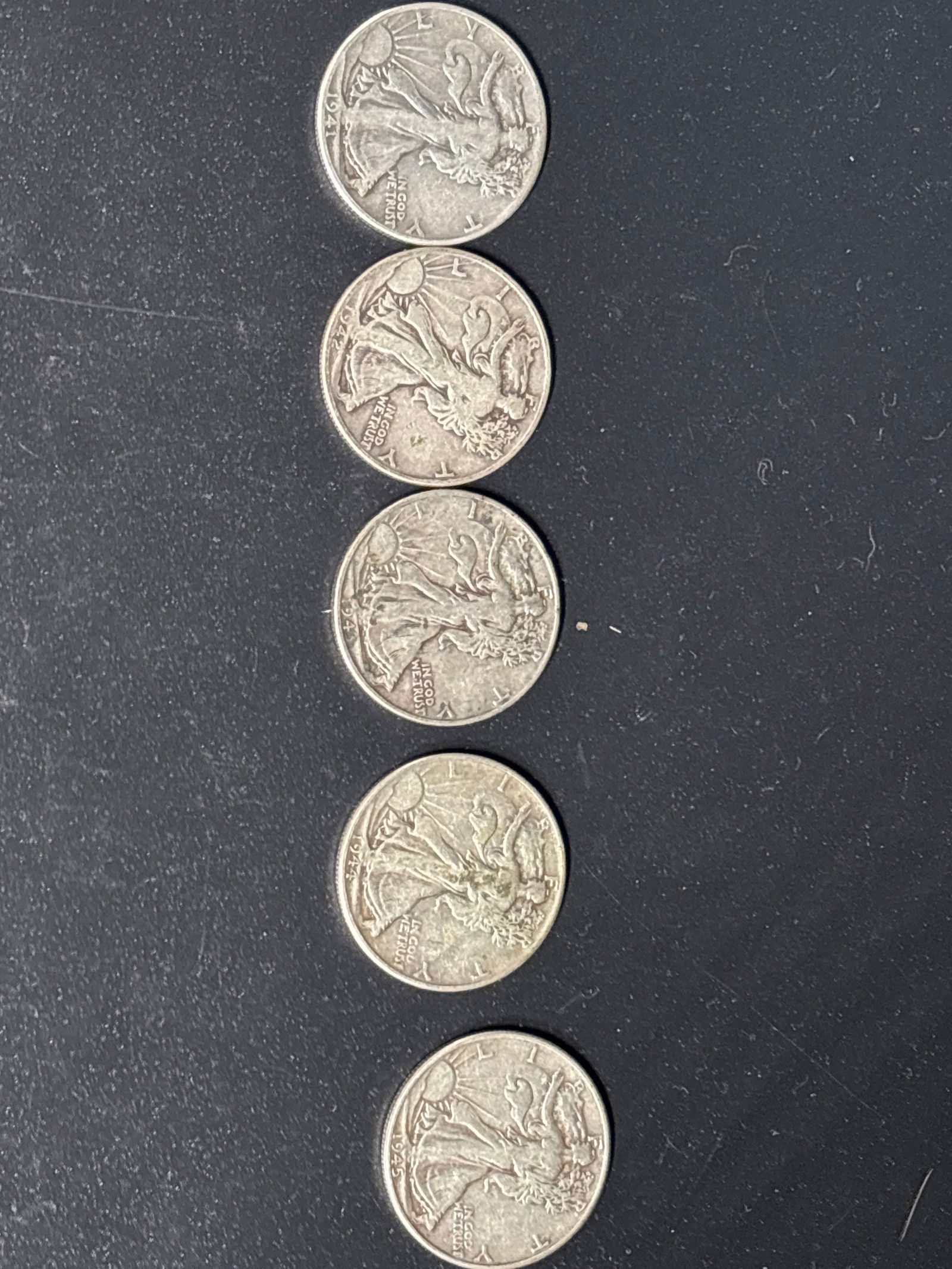 Five sequential WWII era 1940’s silver Walking Liberty Half Dollars: Five sequential WWII era 1940’s Walking Liberty Half Dollars, a 50-cent piece minted by the United States between 1916 and 1947.Key Coin DetailsDesigner: Created by renowned sculptor Adolph A. Weinm