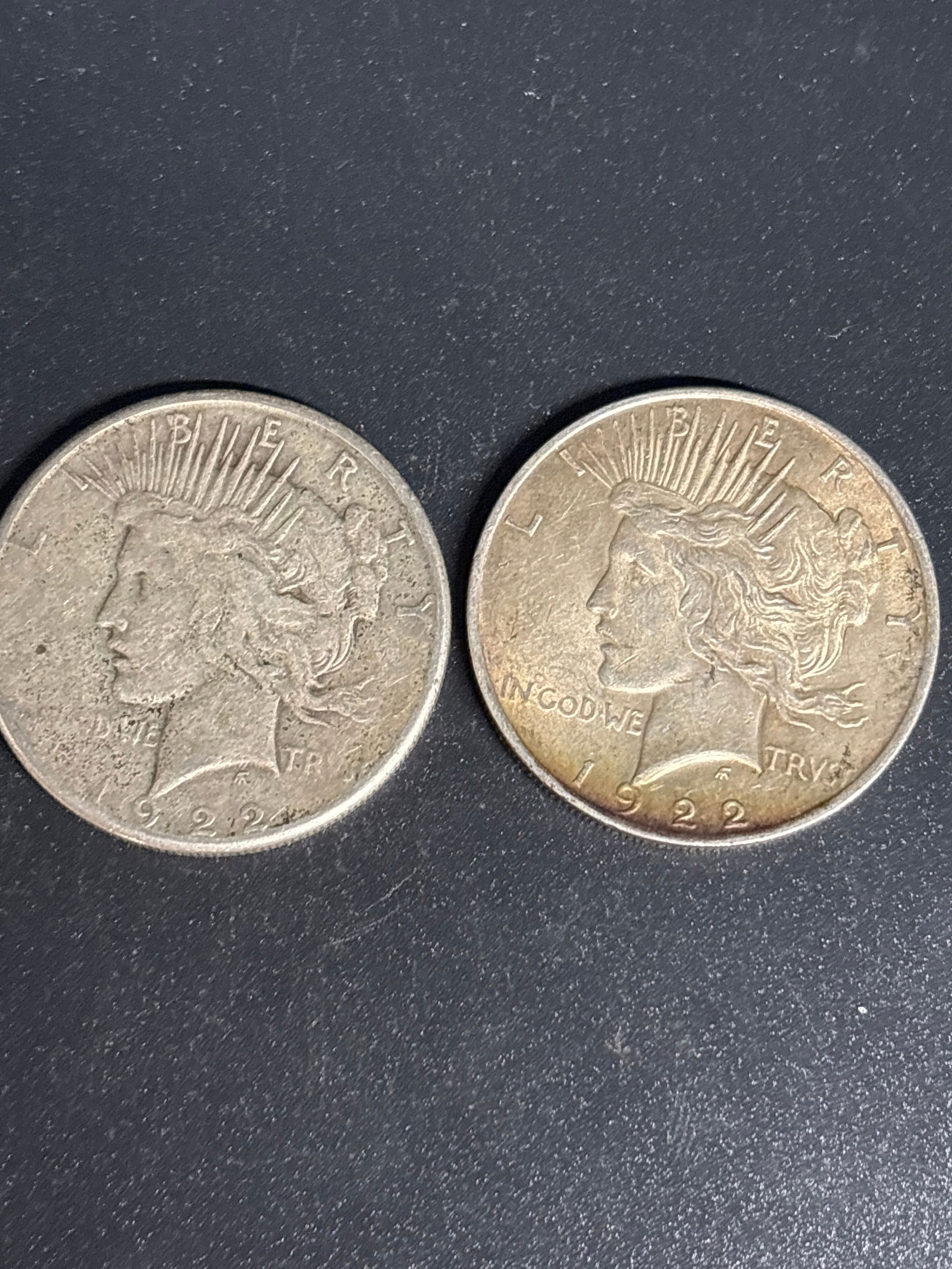 Two 1922 Peace American Silver Dollars: Two 1922 Peace Dollar, a collectible United States silver coin minted between 1921 and 1935. Composition: It is made of 90% silver and 10% copper. Weight: The coin weighs 26.73 grams. Value: As of Mar