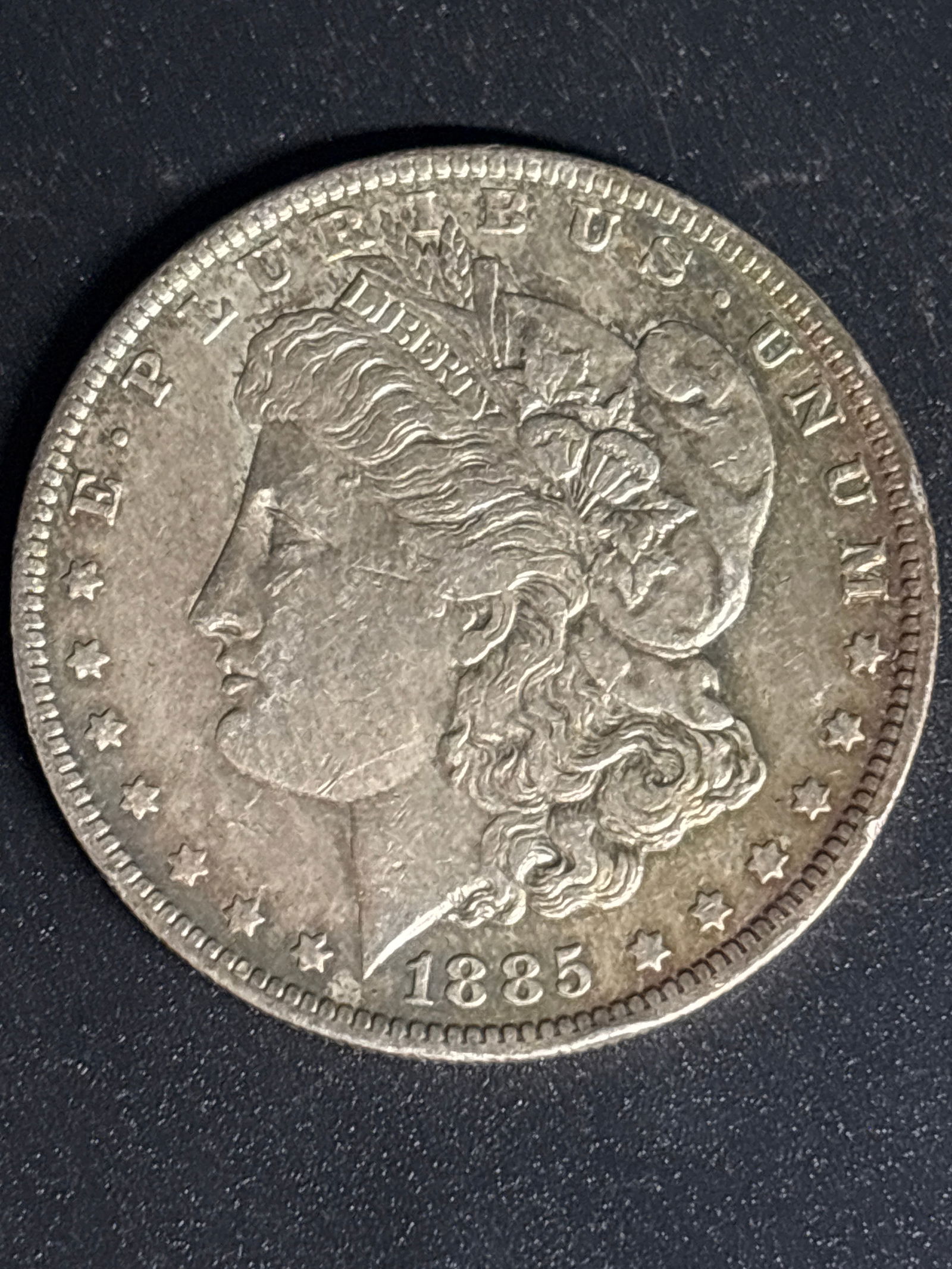 Early date 1885 United States Morgan Silver Dollar: 1885 United States Morgan Silver Dollar, a vintage collectible coin produced from 90% fine silver. Designer: George T. Morgan.Composition: 90% silver, 10% copper.Weight: 26.73 grams