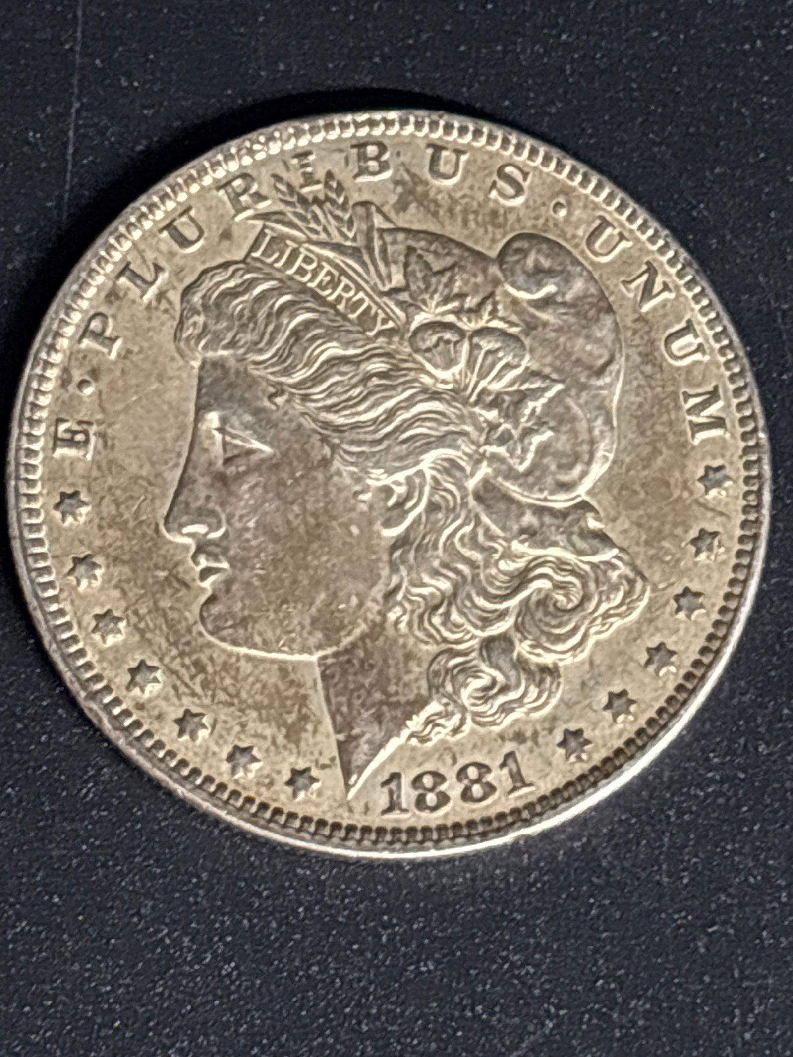 Early 1881 Morgan United States Silver Dollar.: 1881 Morgan Silver Dollar.Composition: It is made of 90% silver and 10% copper, containing 0.77345 troy ounces of pure silver. Design: The obverse features a profile portrait representing Lady Liberty