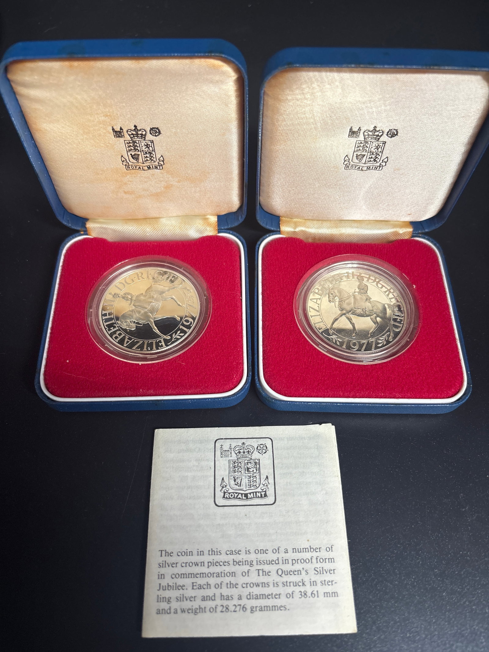 Two .925 silver 1977 Queen Elizabeth II Silver Jubilee Commemorative Crown coins: Two 1977 Queen Elizabeth II Silver Jubilee Commemorative Crown coin. Design: Features an equestrian portrait of Queen Elizabeth II by artist Arnold Machin on the reverse. Material: Struck in solid .92