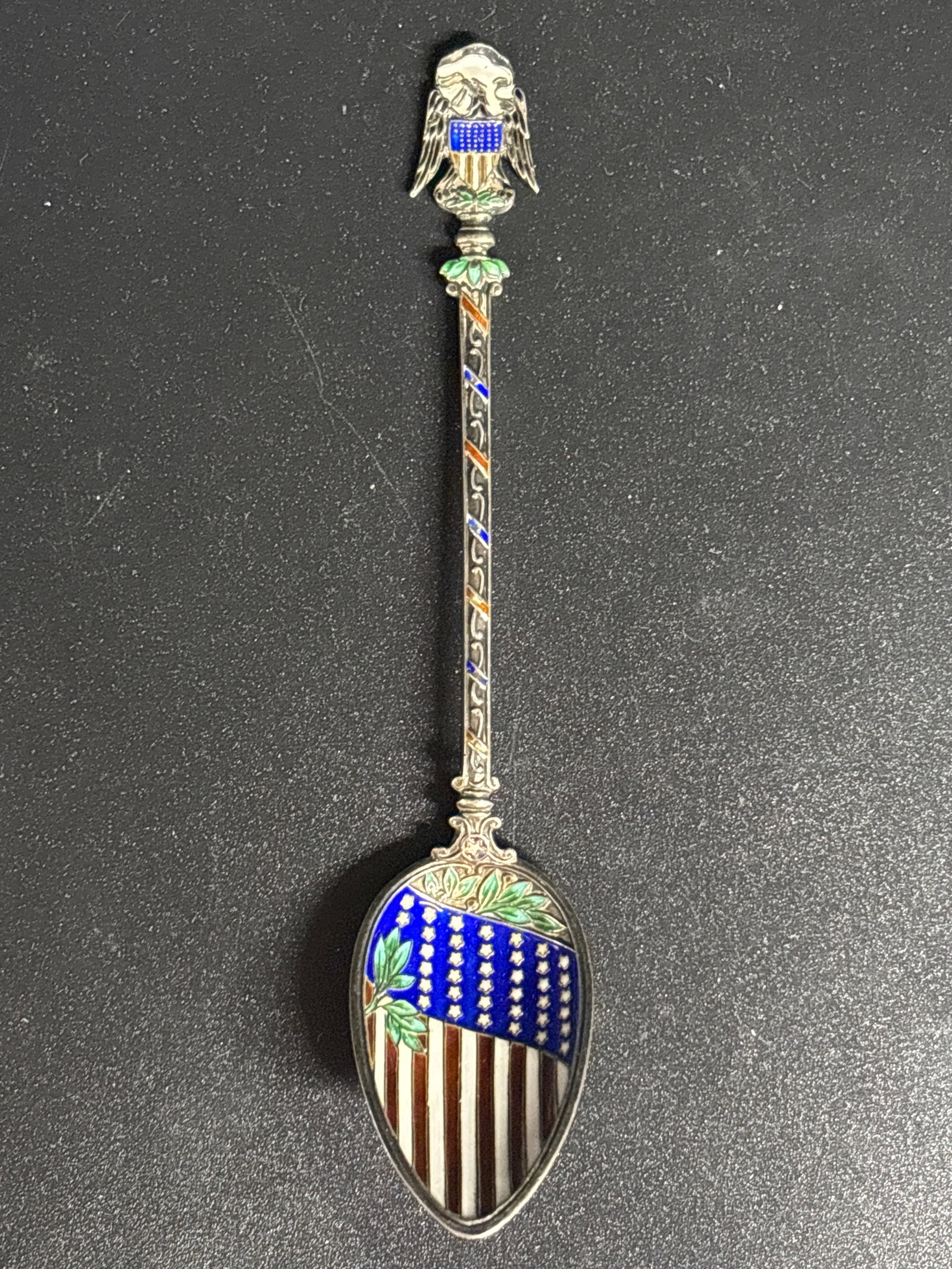 Rare antique American sterling silver souvenir spoon featuring an enameled American flag: Rare antique American sterling silver 4&1/2 inches souvenir spoon featuring an enameled American flag design. 15 grams.Design: The spoon's bowl is decorated with a detailed 38-star American flag, and