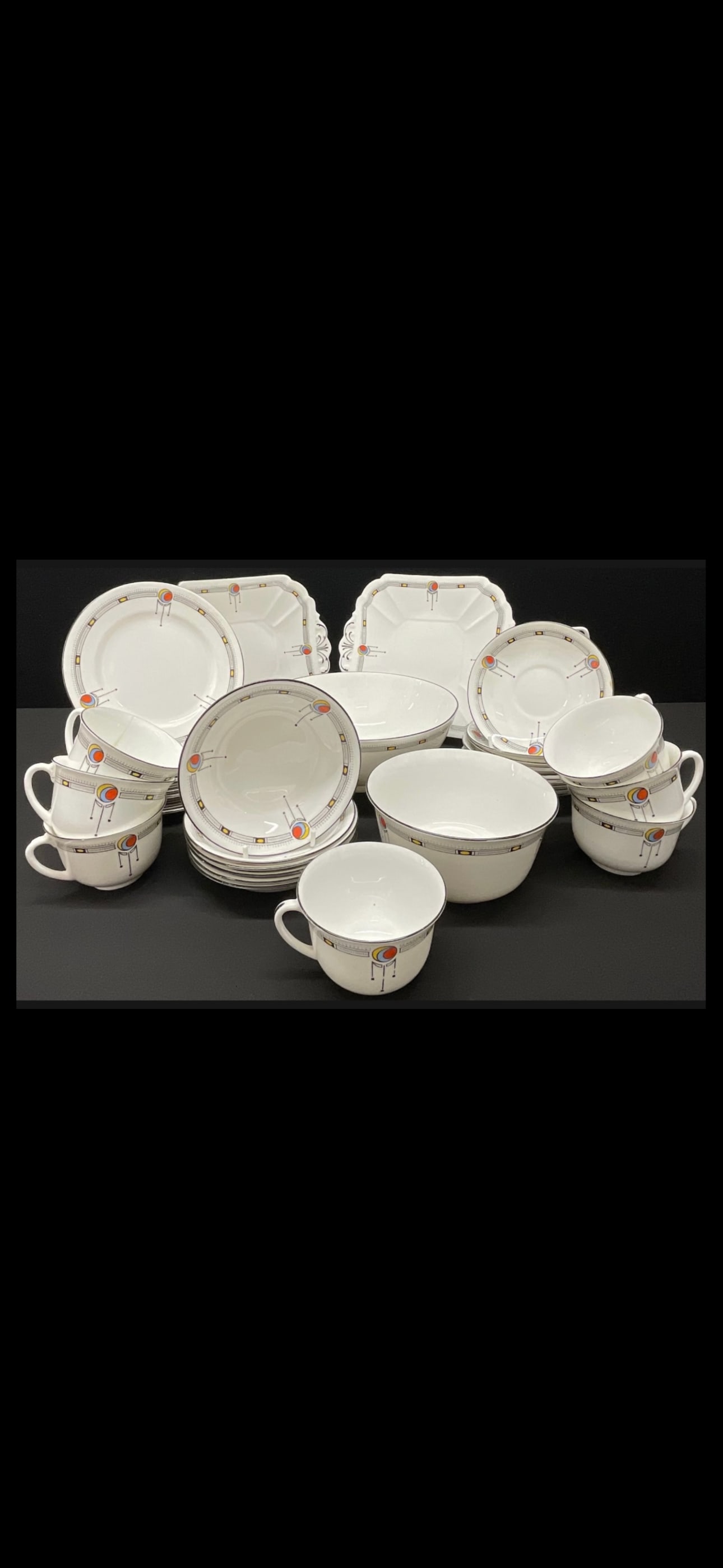 An Art Deco Shelley "Kenneth" shape tea set: An Art Deco Shelley "Kenneth" shape tea set, decorated with brightly coloured spheres amidst monochrome pendants and borders, comprising seven teacups, nine saucers, twelve tea plates, pair of sandwic