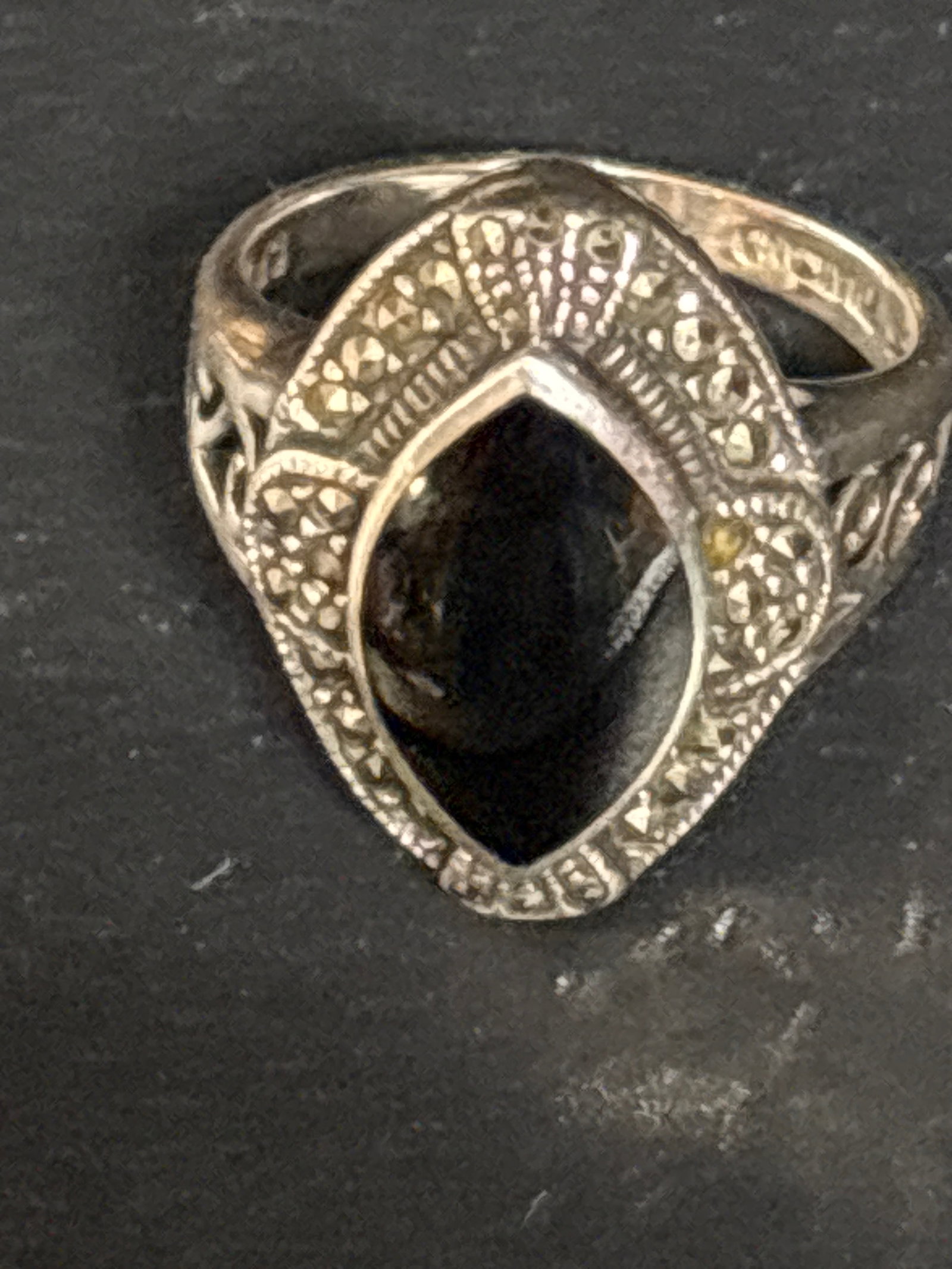 vintage Art Deco-style sterling silver ring with marquise-cut black onyx stone: vintage Art Deco-style sterling silver ring featuring a central marquise-cut black onyx stone. This classic design is characterized by its geometric shape and the use of marcasite stones—small, meta