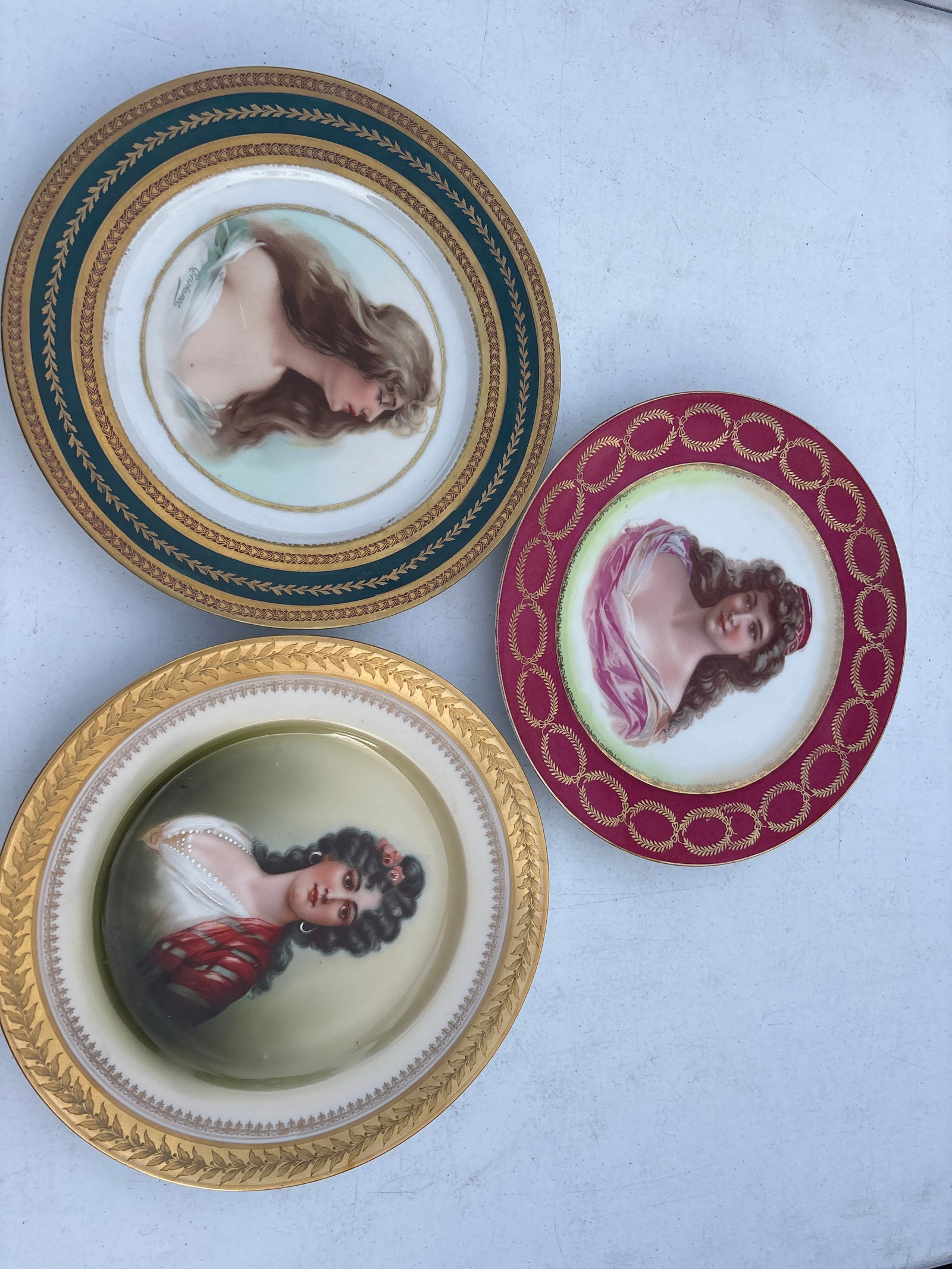 Three antique Austrian 9&1/2 inch porcelain portrait plates: Three antique Austrian 9&1/2 inch porcelain portrait plates including pinkish border Royal Vienna style portrait plate featuring a Victorian-style lady. Design: It typically features a burgundy