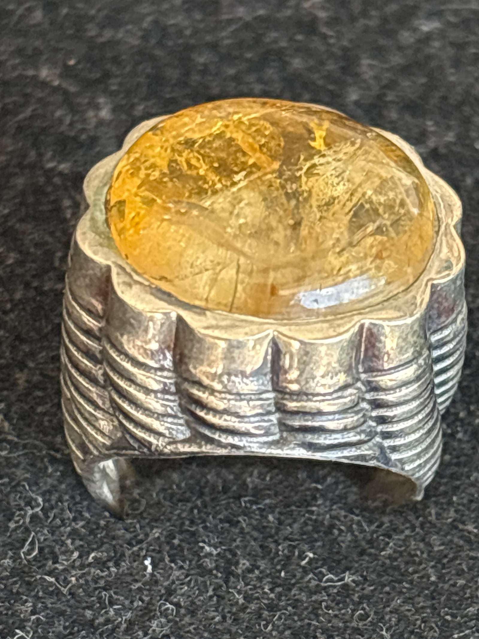 Big sterling silver distinctive golden gemstone ring 16 grams: distinctive golden gemstone—likely golden rutilated quartz or citrine—set in a heavily textured, handmade 925 sterling silver band.Key FeaturesGemstone: The stone is a yellowish-gold cabochon.